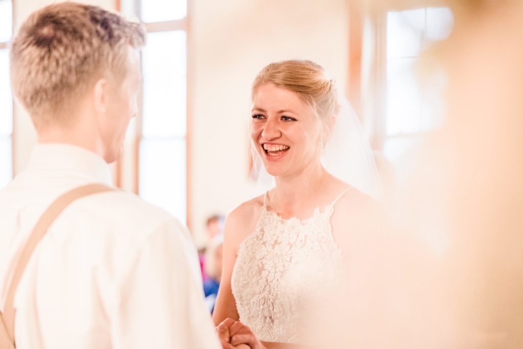 Bride smiles at her groom during her wedding at at the Fork of Cheat Baptist Church in Morgantown, West Virginia.  Photo by Austin Wedding Photographers, Joanna & Brett