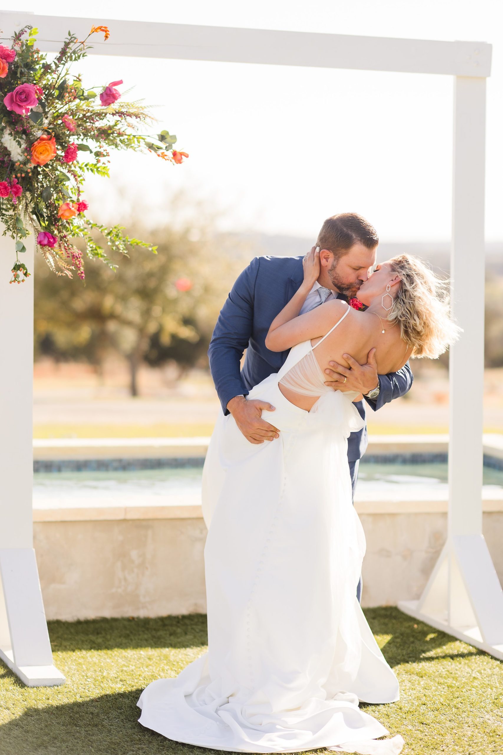 First Kiss at the Camp Hideaway Retreat wedding venue in Fredericksburg, Texas. Photograph taken by Austin wedding photographers, Joanna and Brett Photography.
