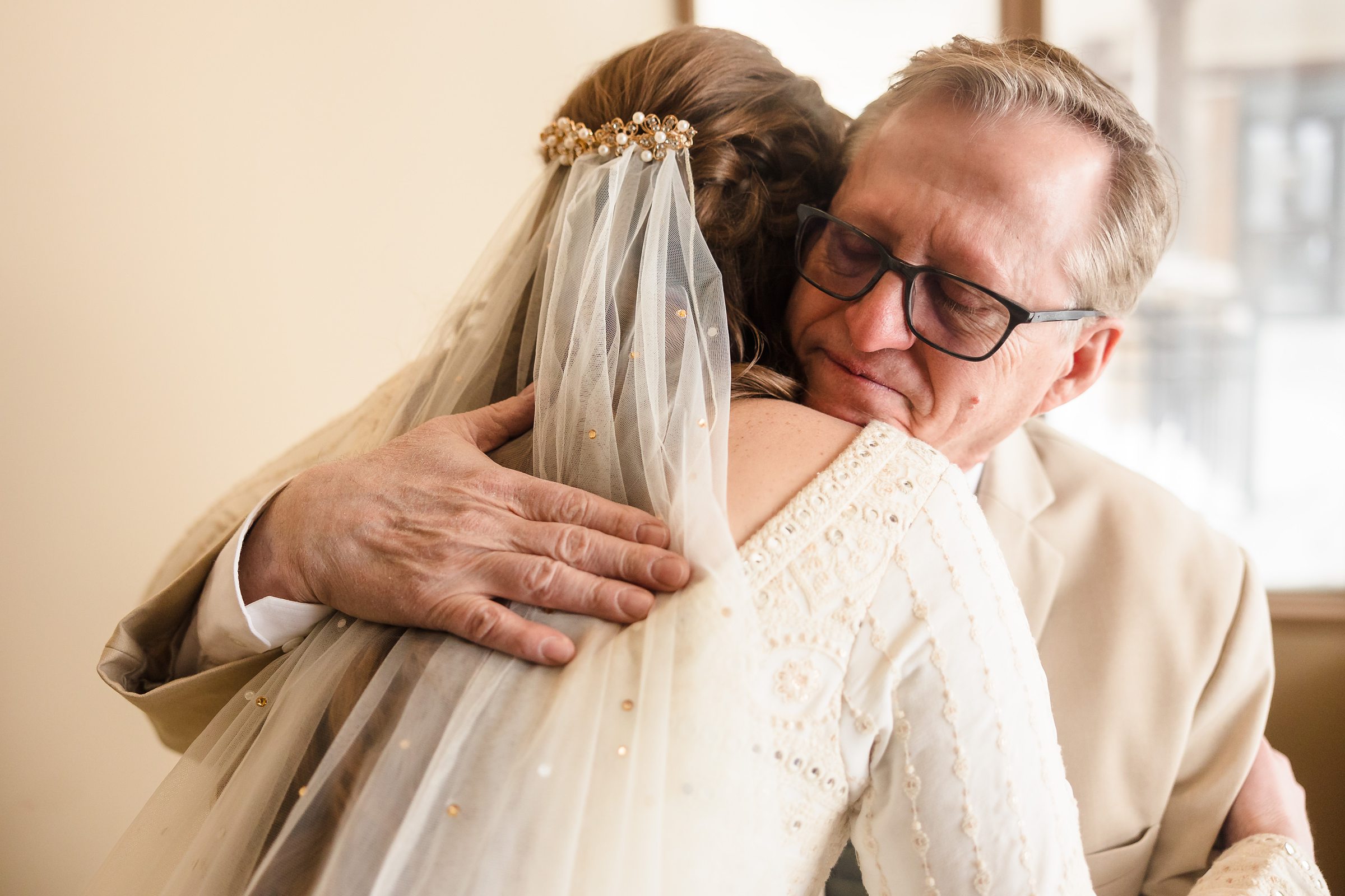 Bride hugs her dad during her wedding in Bloomington-Normal, Illinois.