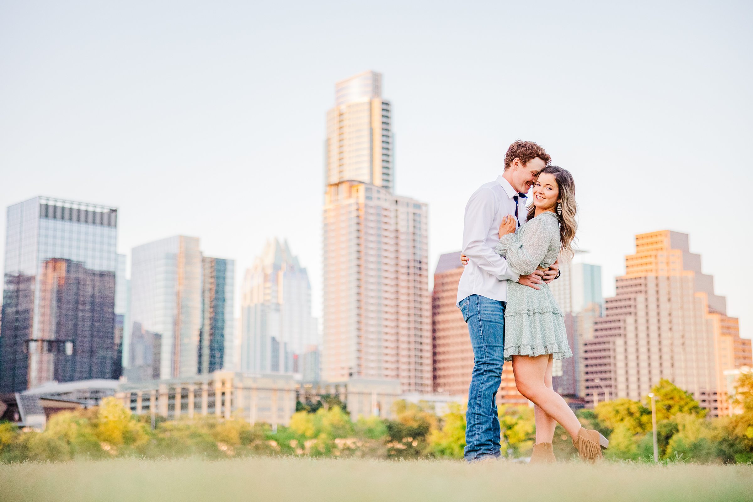 Couple embrace during their engagement session at Butler Park in Austin, Texas.