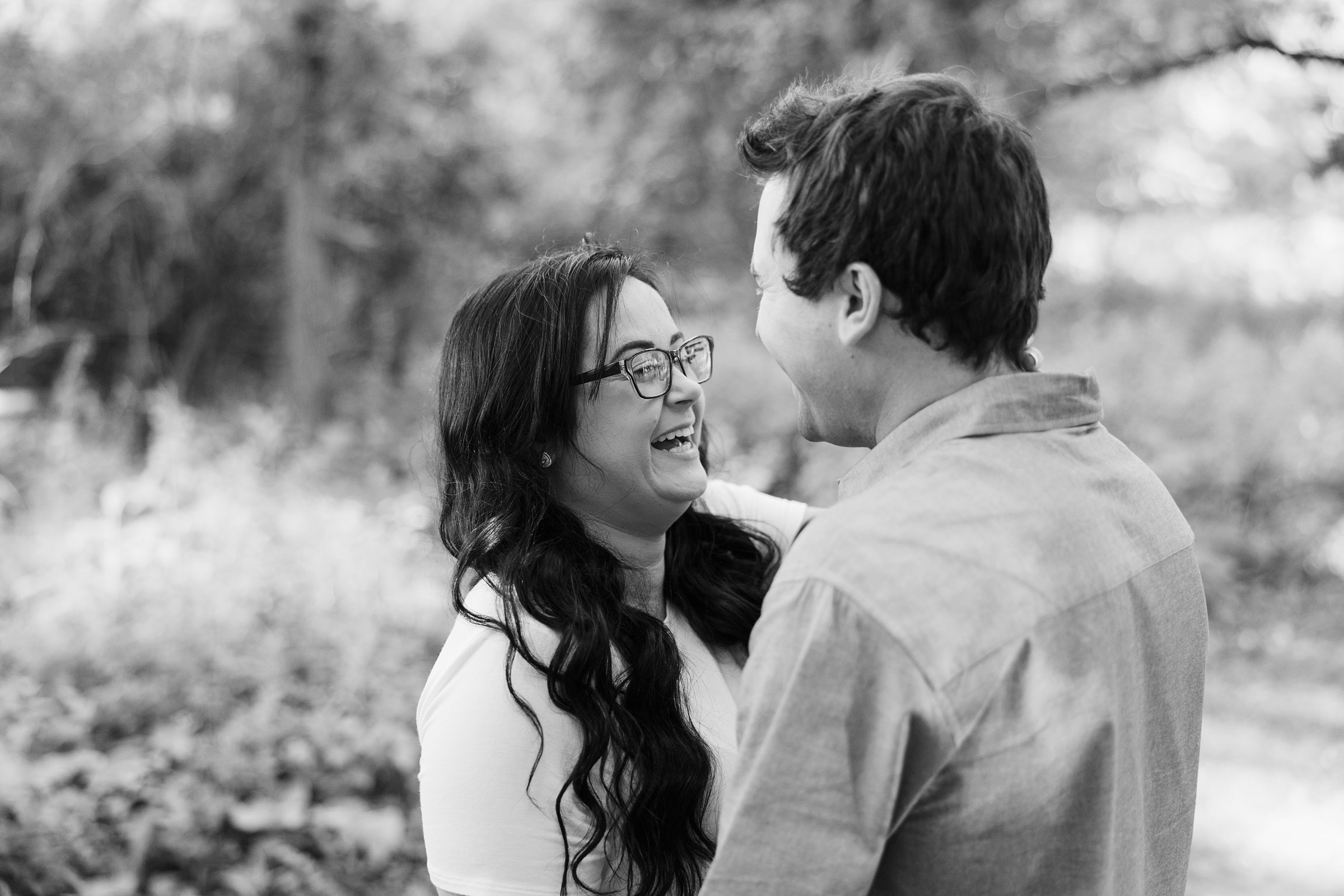 Couple laugh together during their engagement session at the Chain O Lakes State Park in Fox Lake, Illinois.