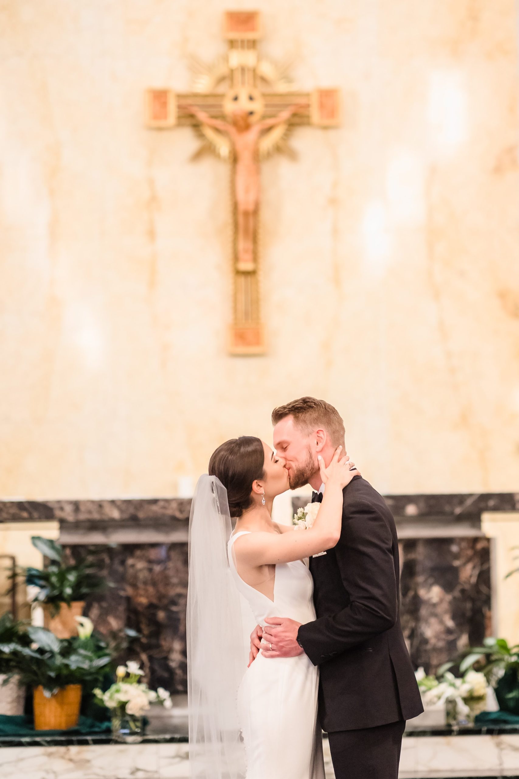 Bride and groom share their first kiss during their wedding at Our Lady of the Wayside Church in Illinois.