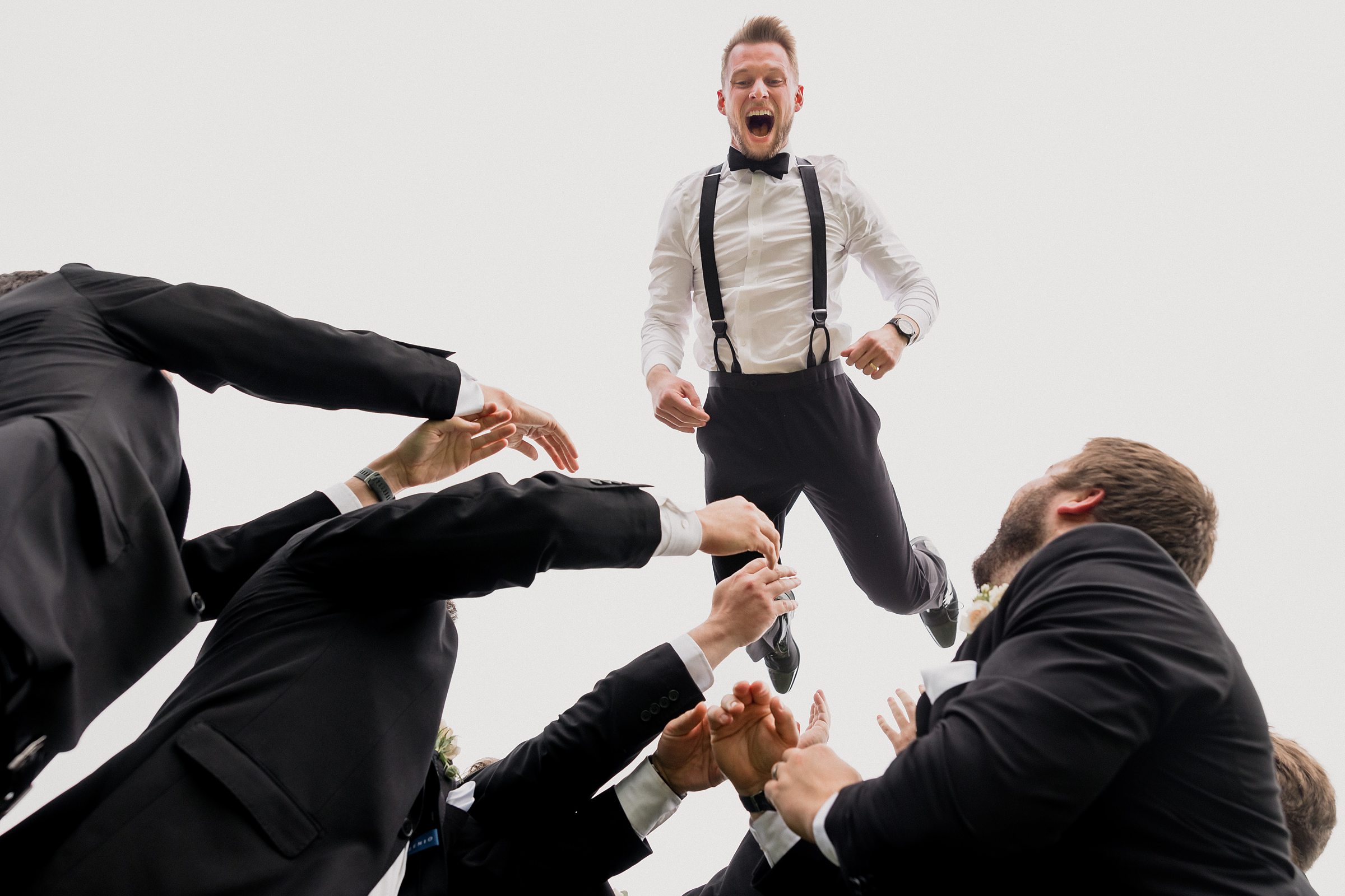 Groomsmen throw the groom into the air during a wedding at the Chevy Chase Country Club in Wheeling, Illinois.