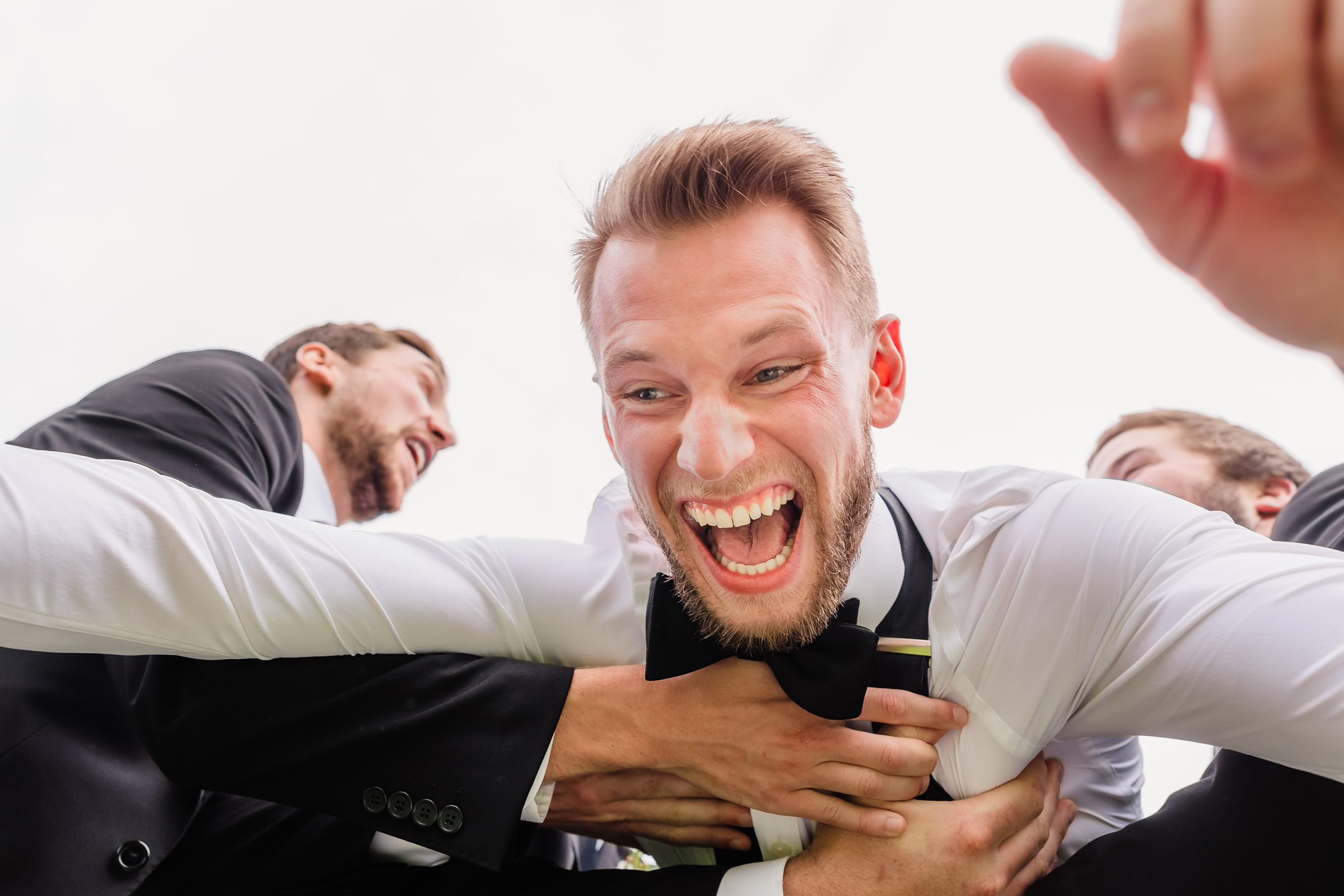 Groomsmen catch the groom during his wedding at the Chevy Chase Country Club in Wheeling, Illinois.