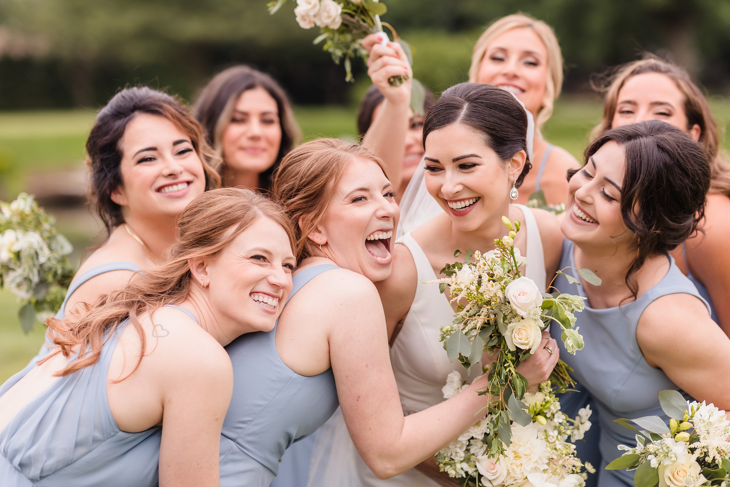 Bridesmaids surprise hug the bride during her wedding at the Chevy Chase Country Club in Wheeling, Illinois.