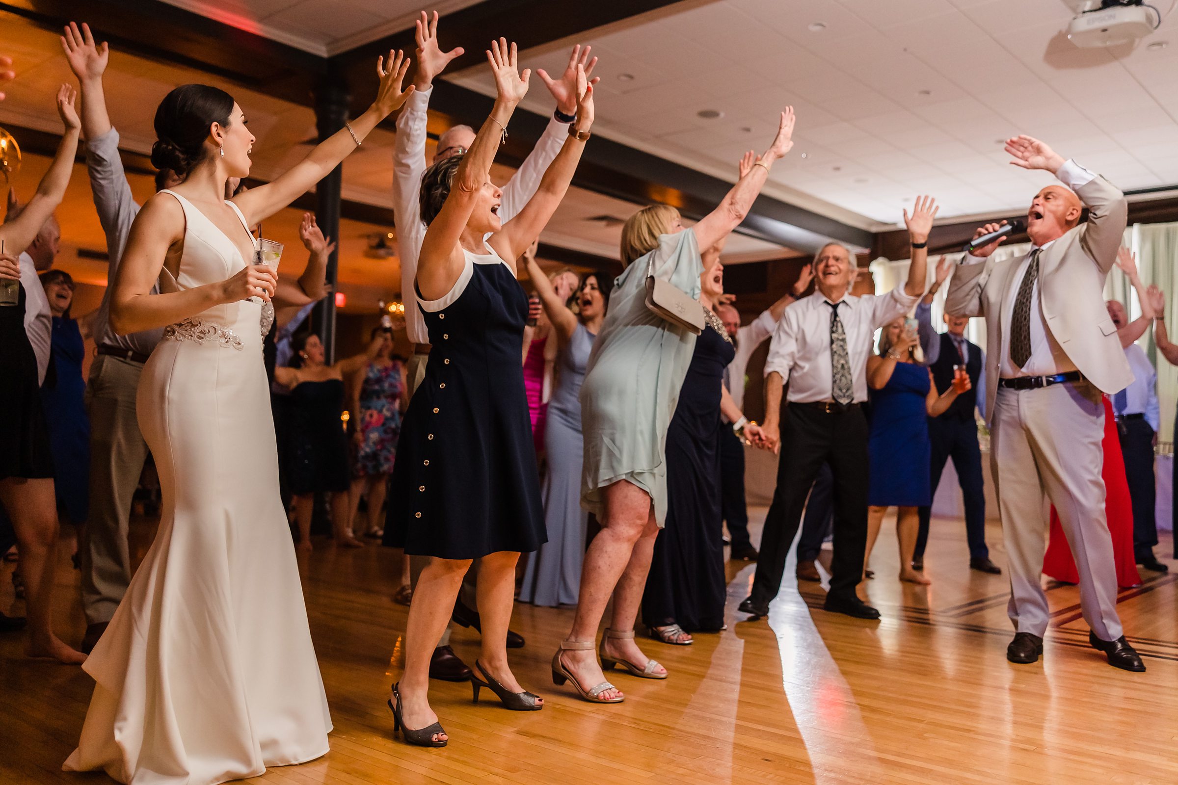 Everyone sings together during a wedding at the Chevy Chase Country Club in Wheeling, Illinois.