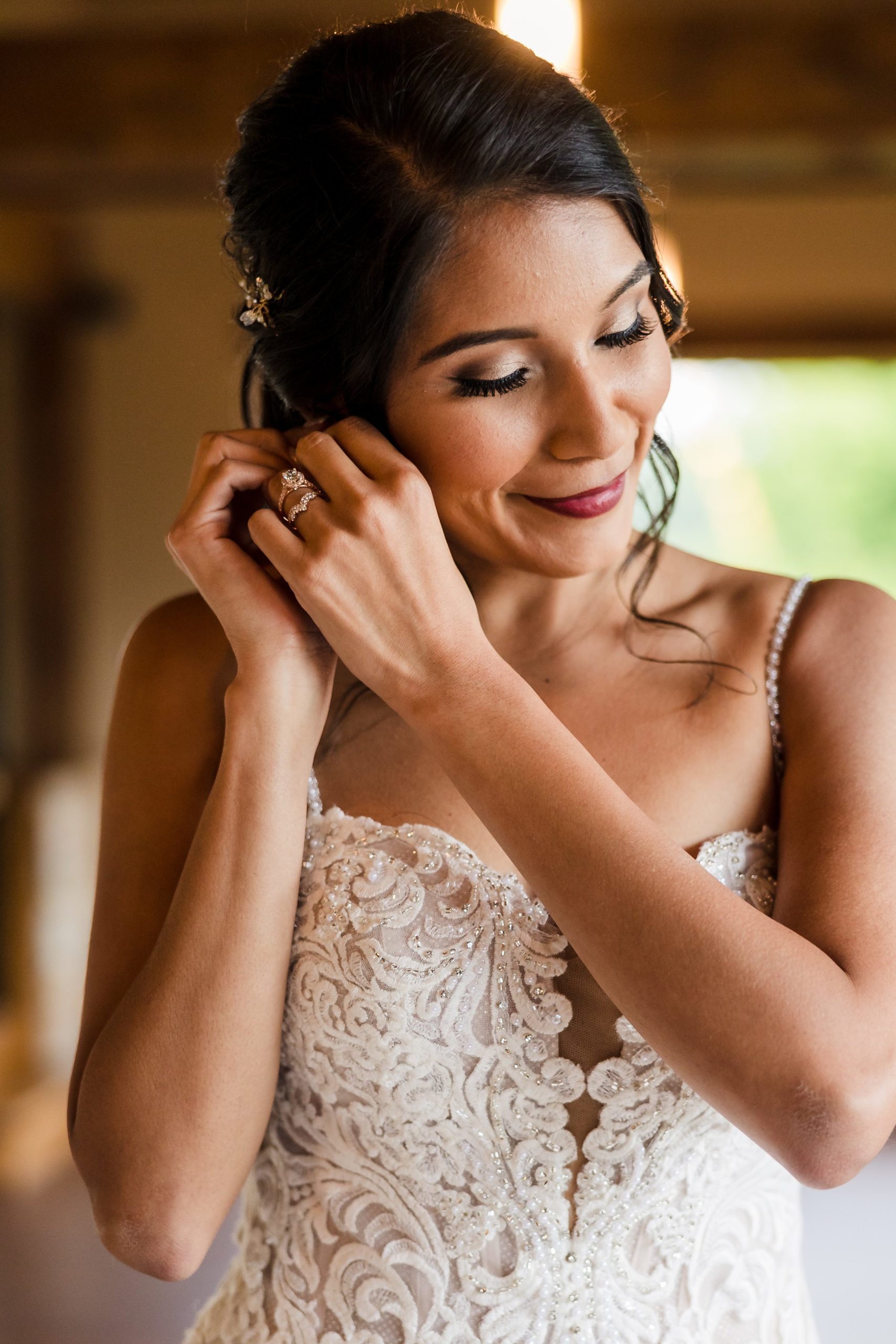 Bride puts on her earings before her wedding at the Fisherman's Inn in Elburn, Illinois.