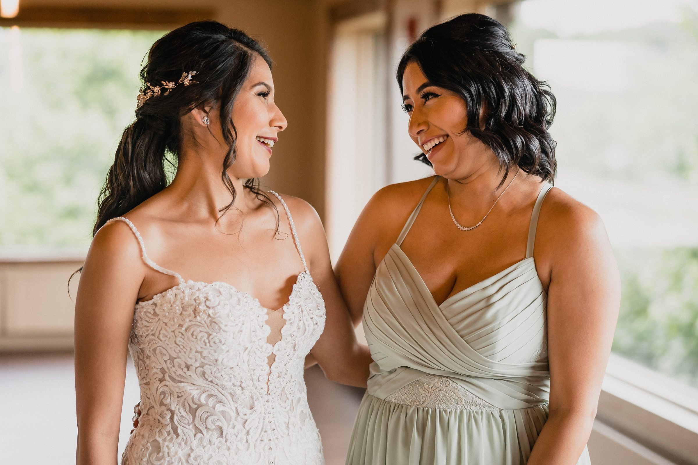 Bride and her sister laugh together during her wedding at the Fisherman's Inn in Elburn, Illinois.