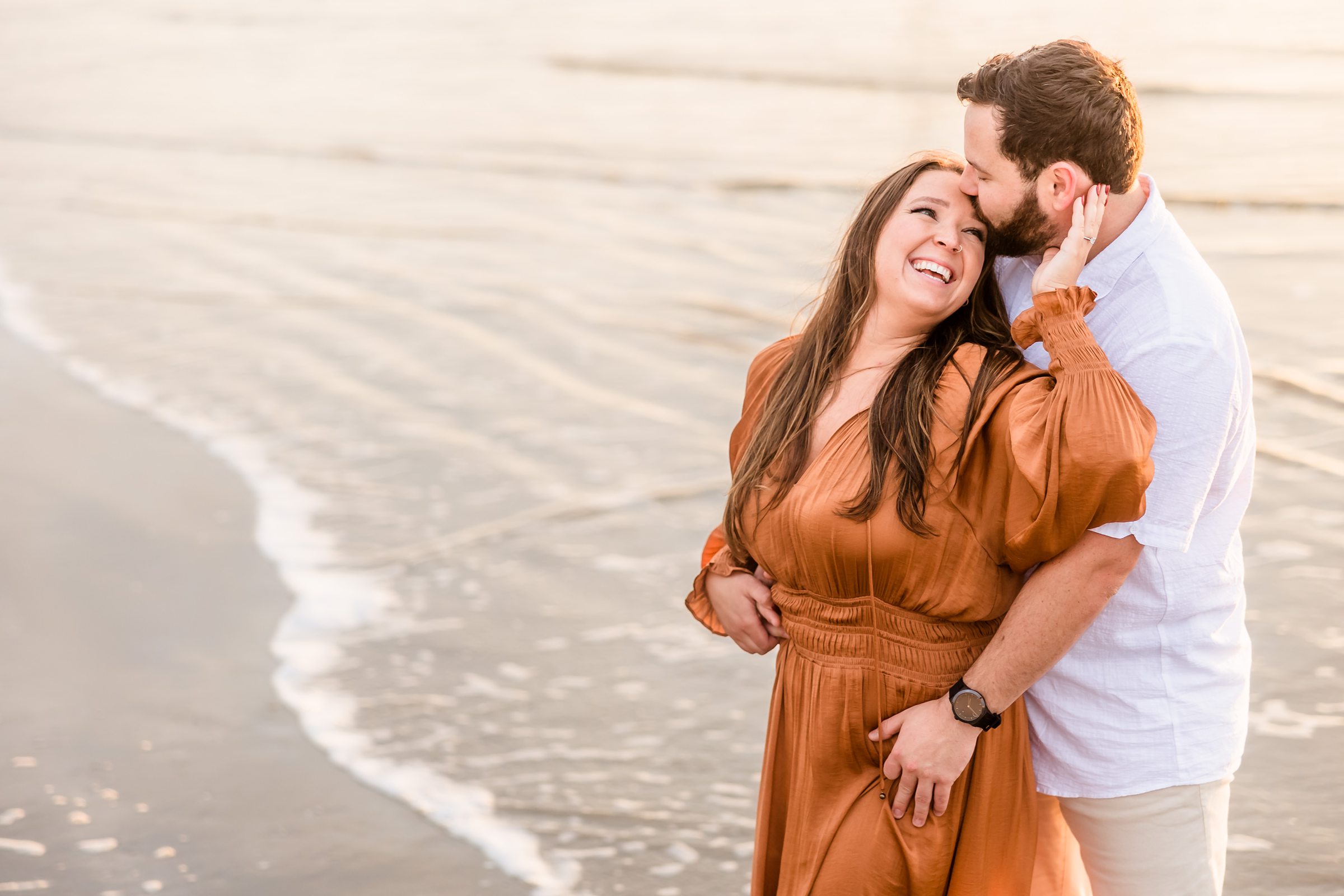 Couple embrace during their Galveston Beach engagement session.