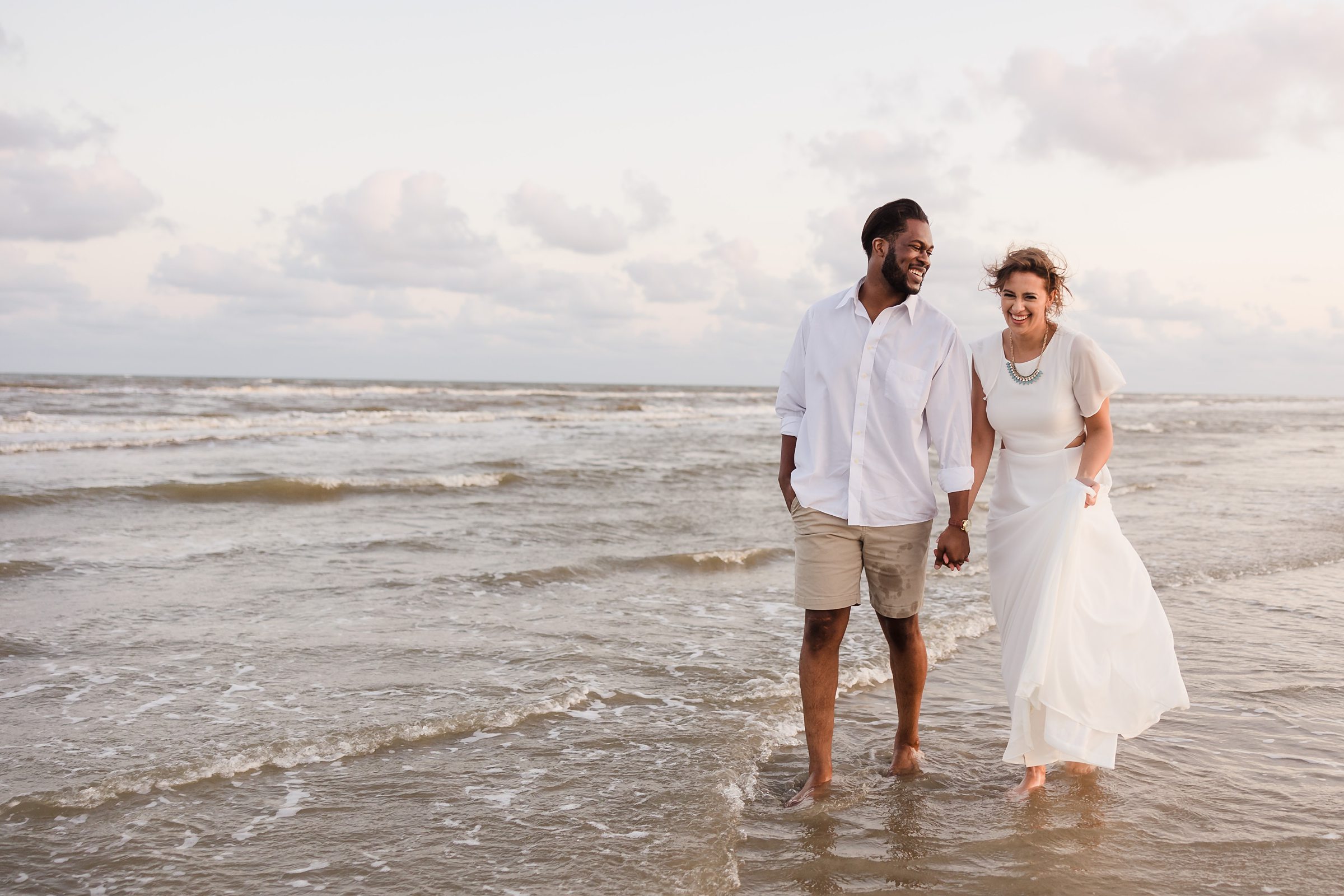 Couple walk together during their session at Galveston Beach in Texas.