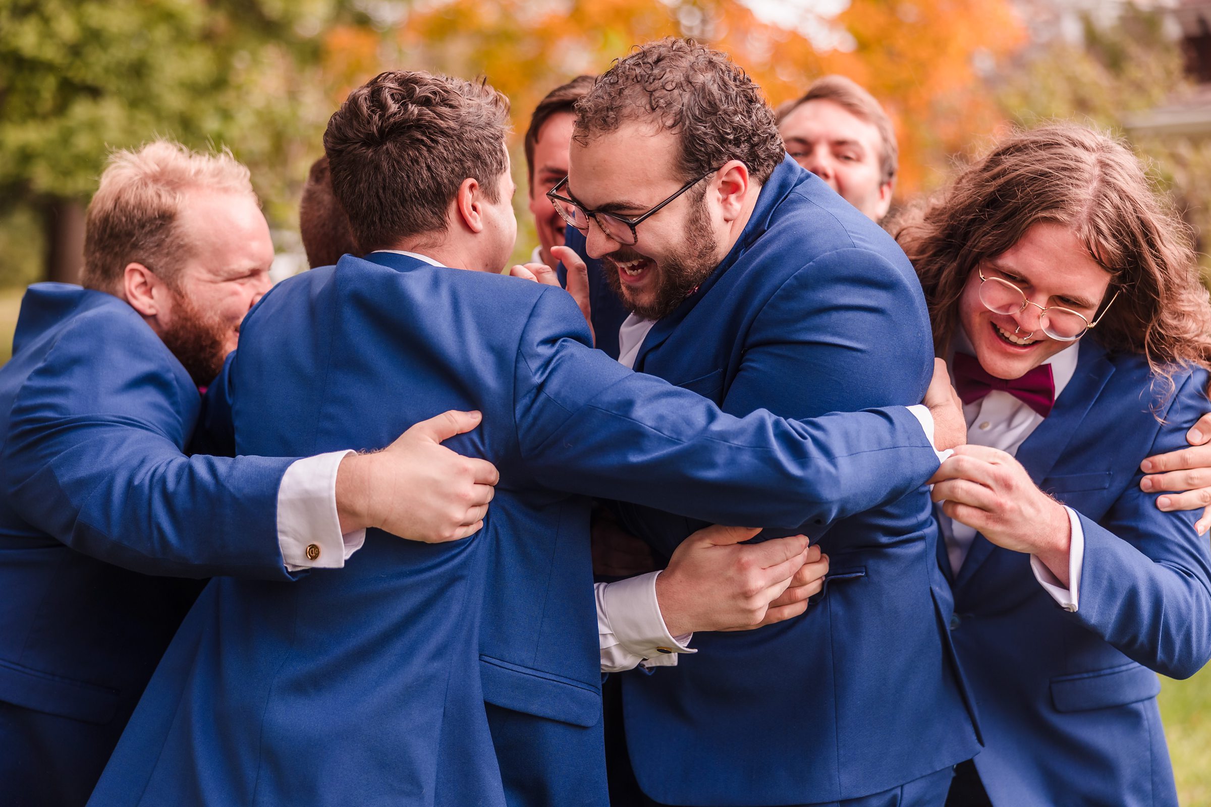 Groomsmen hug groom before a wedding at the Hotel Pere Marquette in Peoria, Illinois.