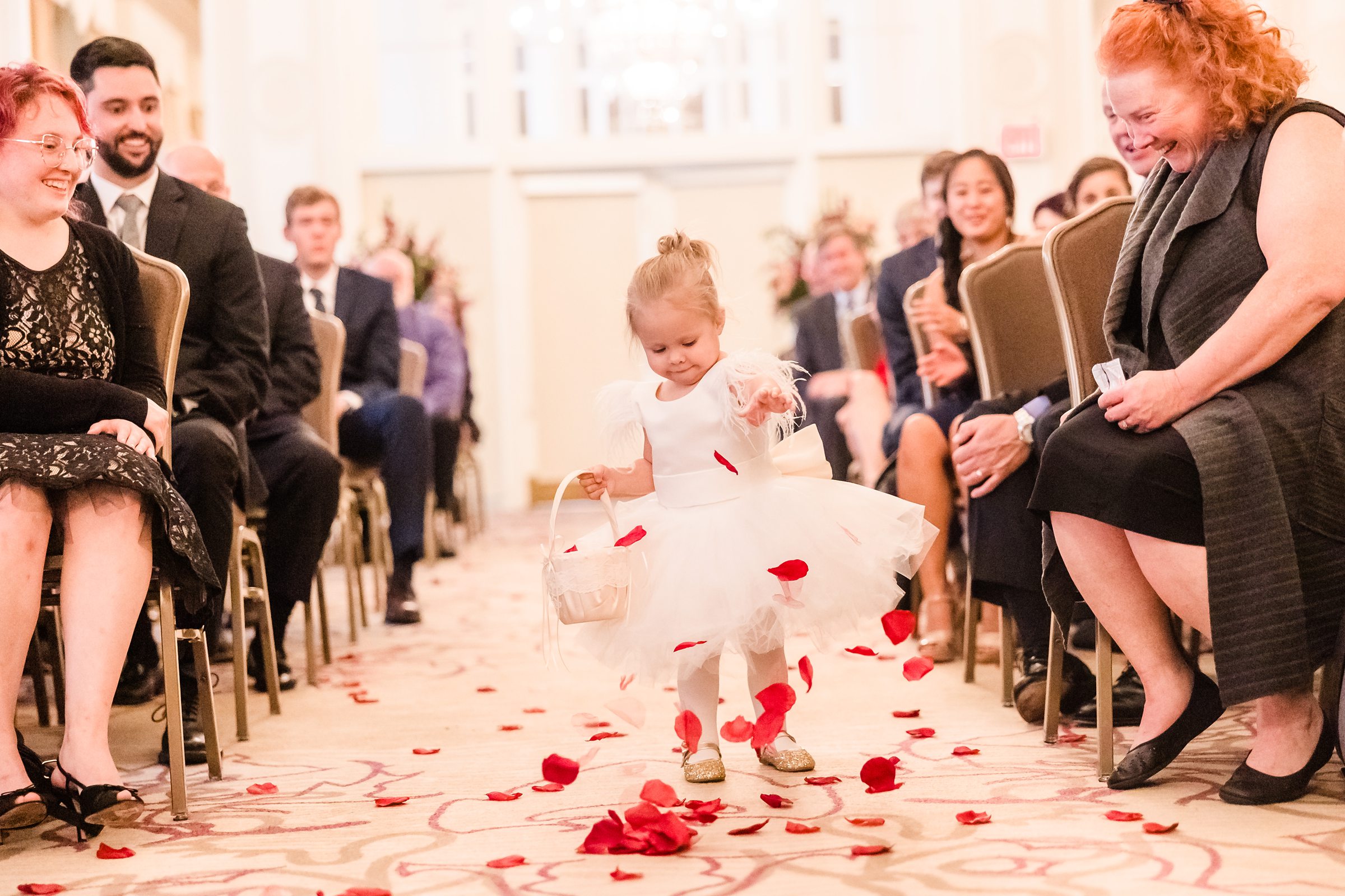 Flowergirl drops flower peddles during a wedding ceremony at the Hotel Pere Marquette in Peoria, Illinois.