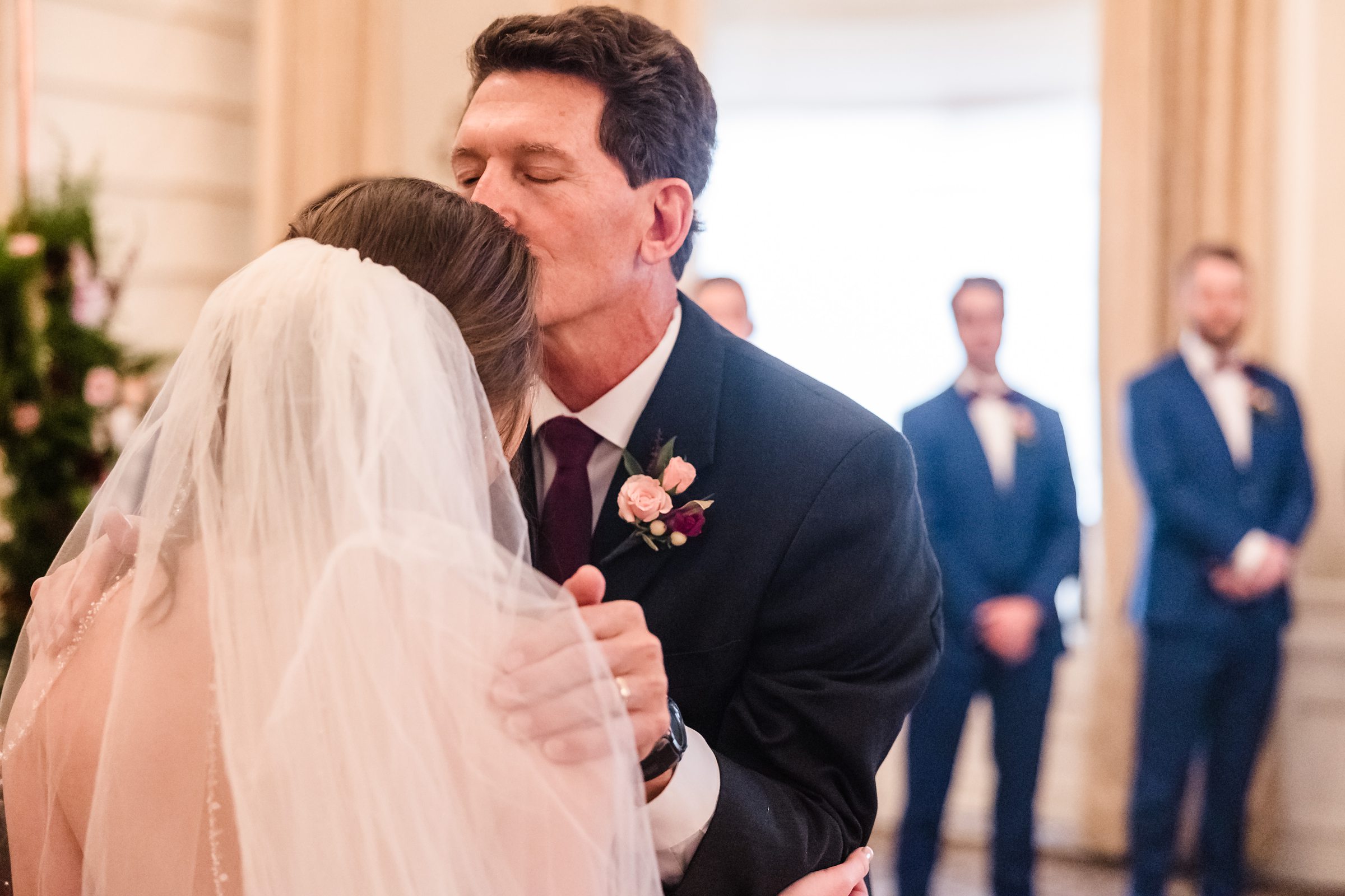 Father kisses his daughter on the forehead during her wedding at the Hotel Pere Marquette in Peoria, Illinois.