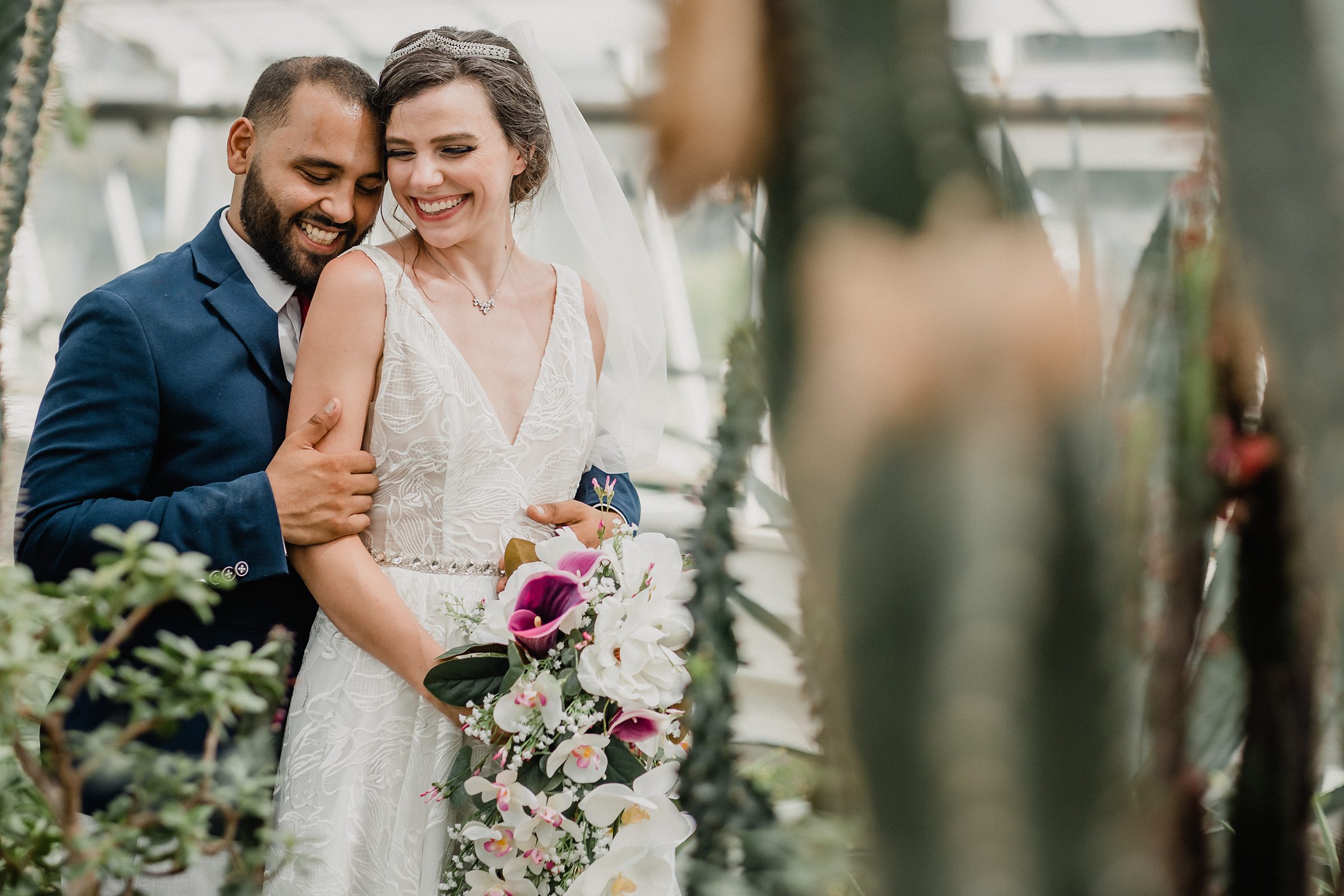 Couple embrace during their wedding at the Bird Haven Greenhouse & Conservatory in Joliet, Illinois