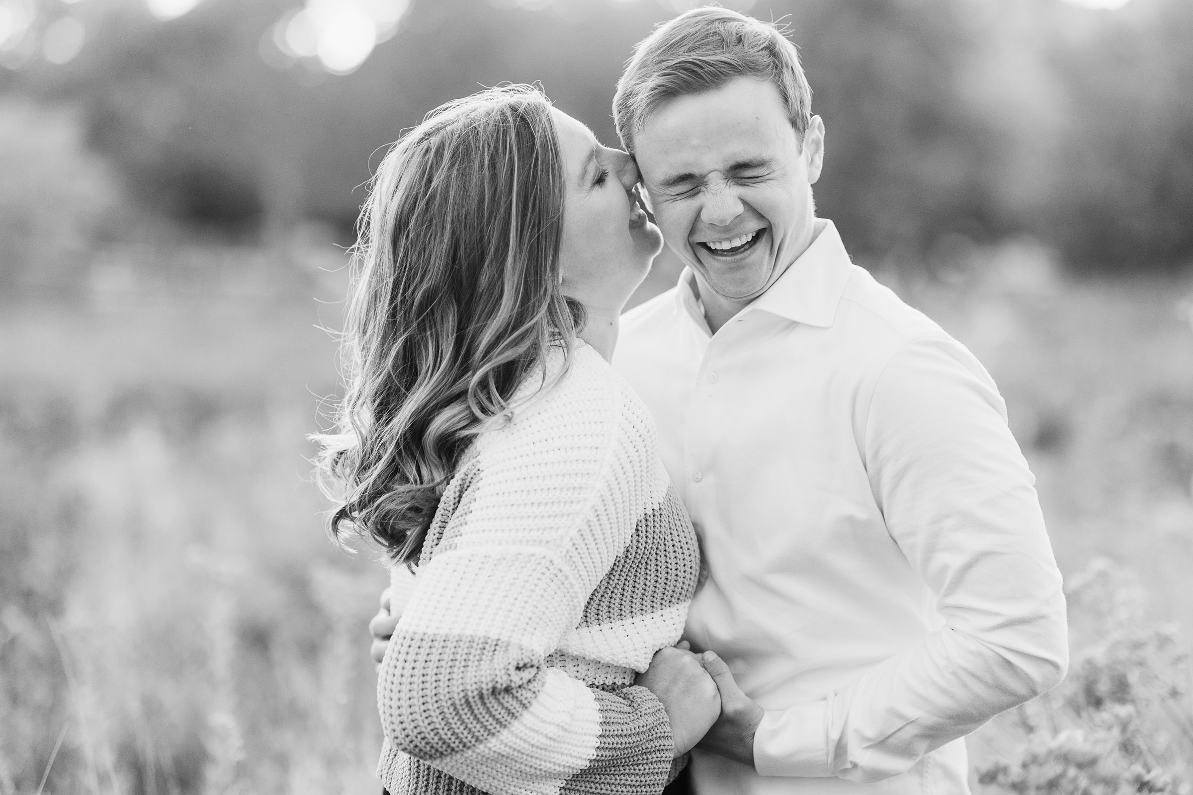 Couple laugh together during their engagement sessionat Lincoln Park in Chicago, Illinois.