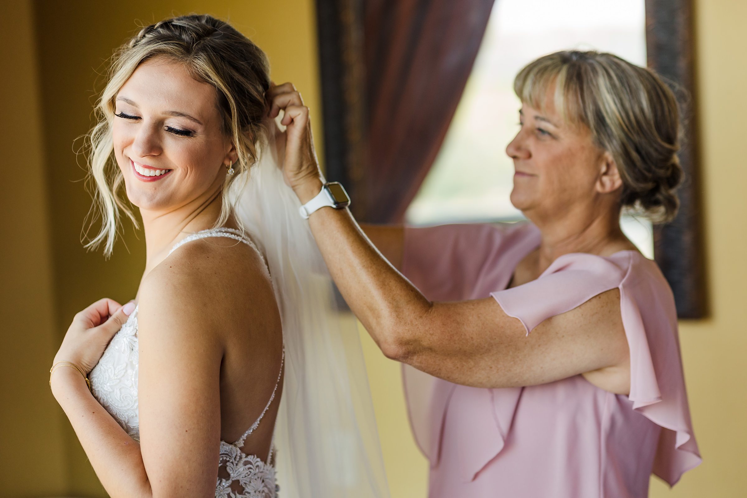 Mom puts the brides veil before her wedding at the Luthy Botanical Garden in Peoria, Illinois