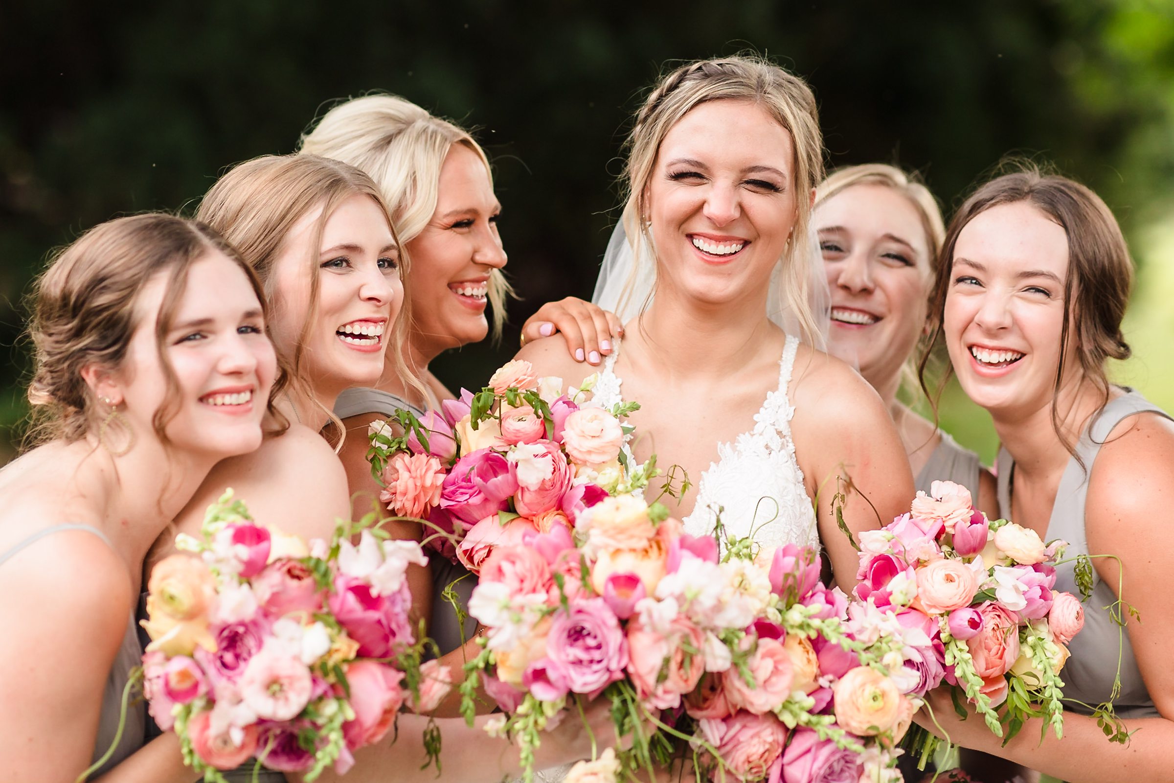 Bridesmaids hug bride during her wedding at the Luthy Botanical Garden in Peoria, Illinois