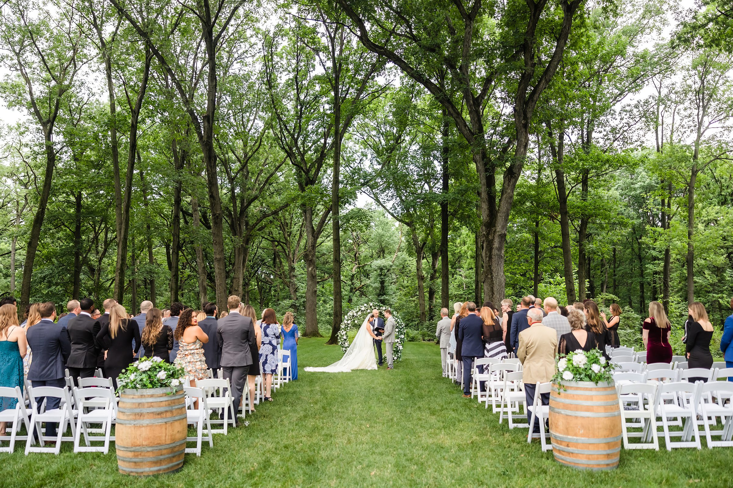 Friends and family look on during a wedding ceremony at the Monte Bello Estate in Lemont, Illinois