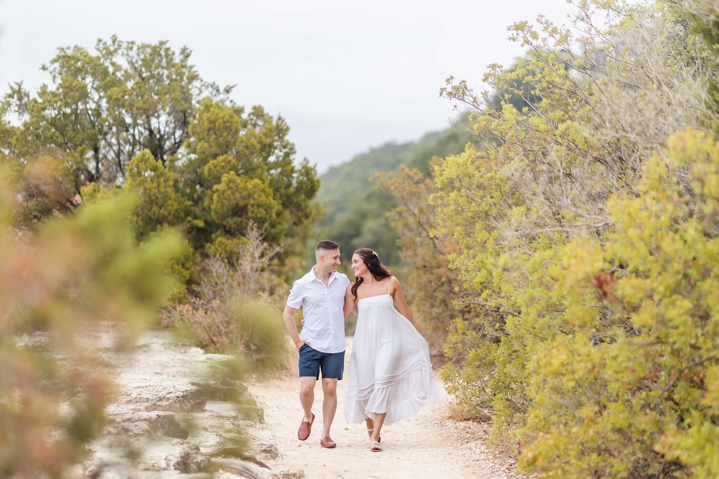 Couple walk together during their engagement session at Mount Bonnell in Austin, Texas.