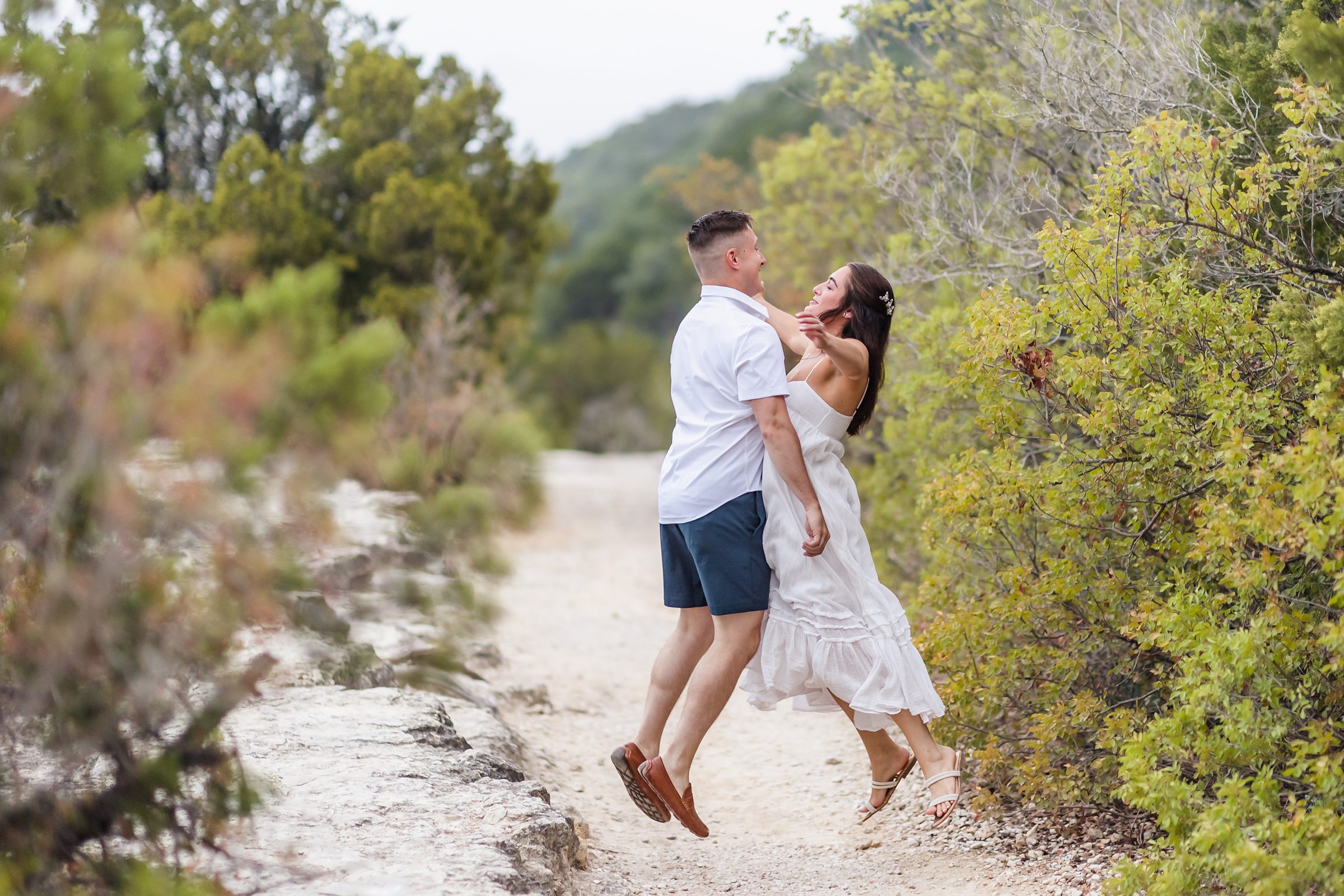 Couple chest bump each other during their engagement session at Mount Bonnell in Austin, Texas.