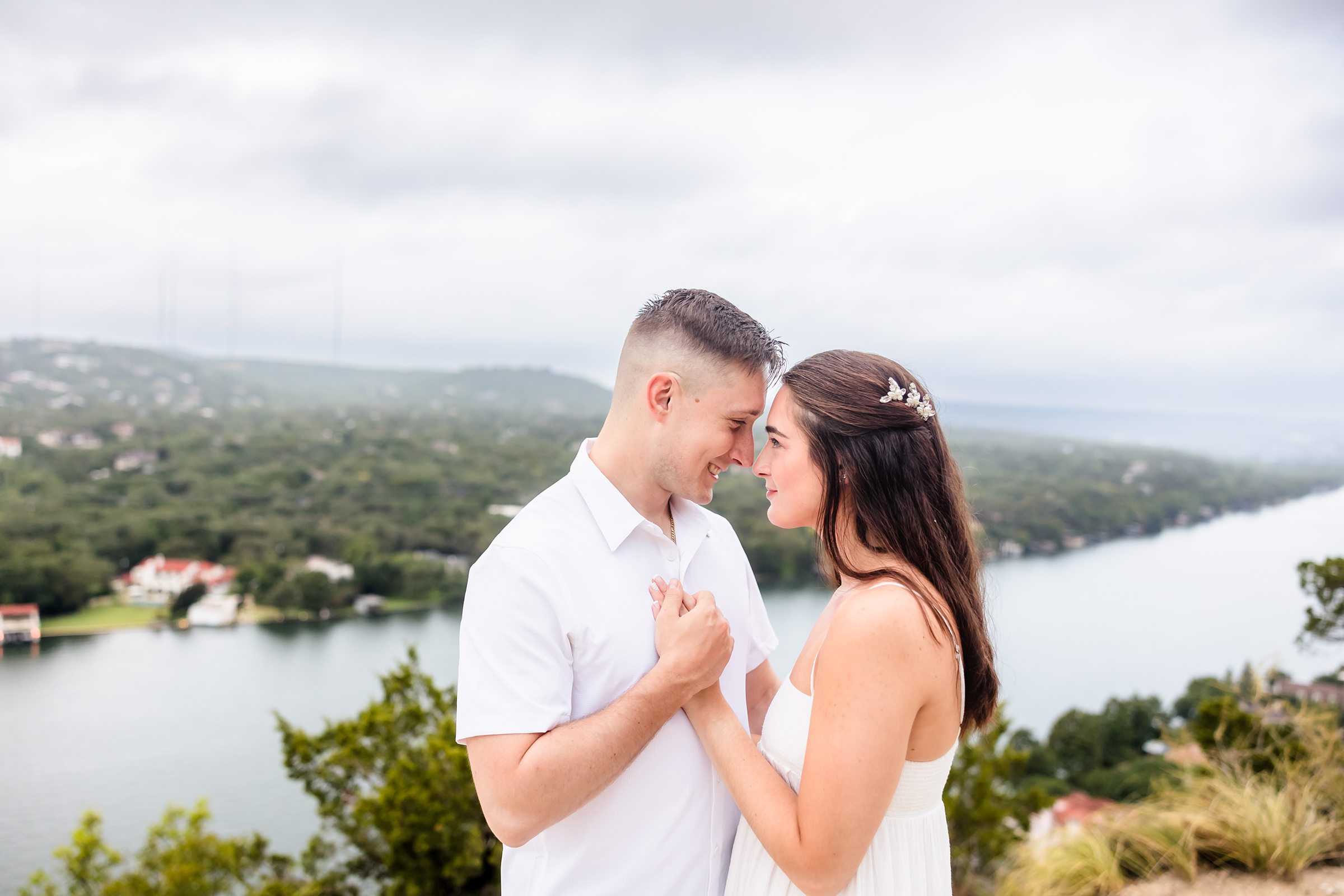 Couple embrace during their engagement session at Mount Bonnell in Austin, Texas.
