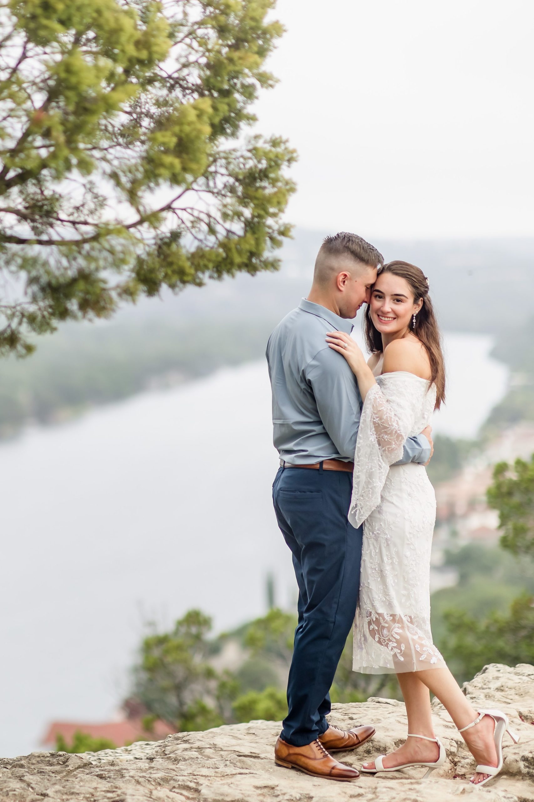 Couple embrace during their engagement session at Mount Bonnell in Austin, Texas.