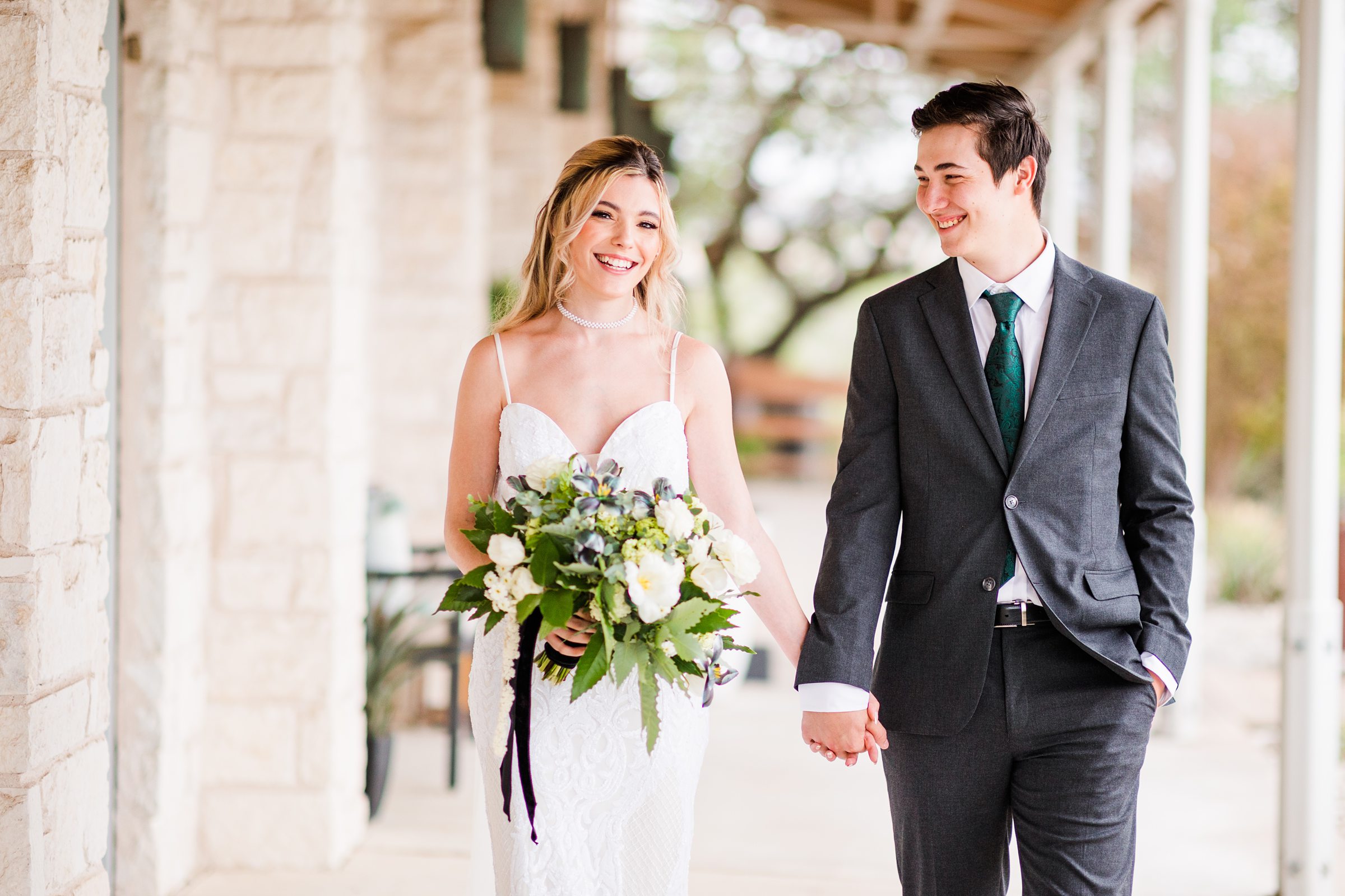 Bride and groom walk during their wedding at the Terrace Club in Dripping Springs, Texas.