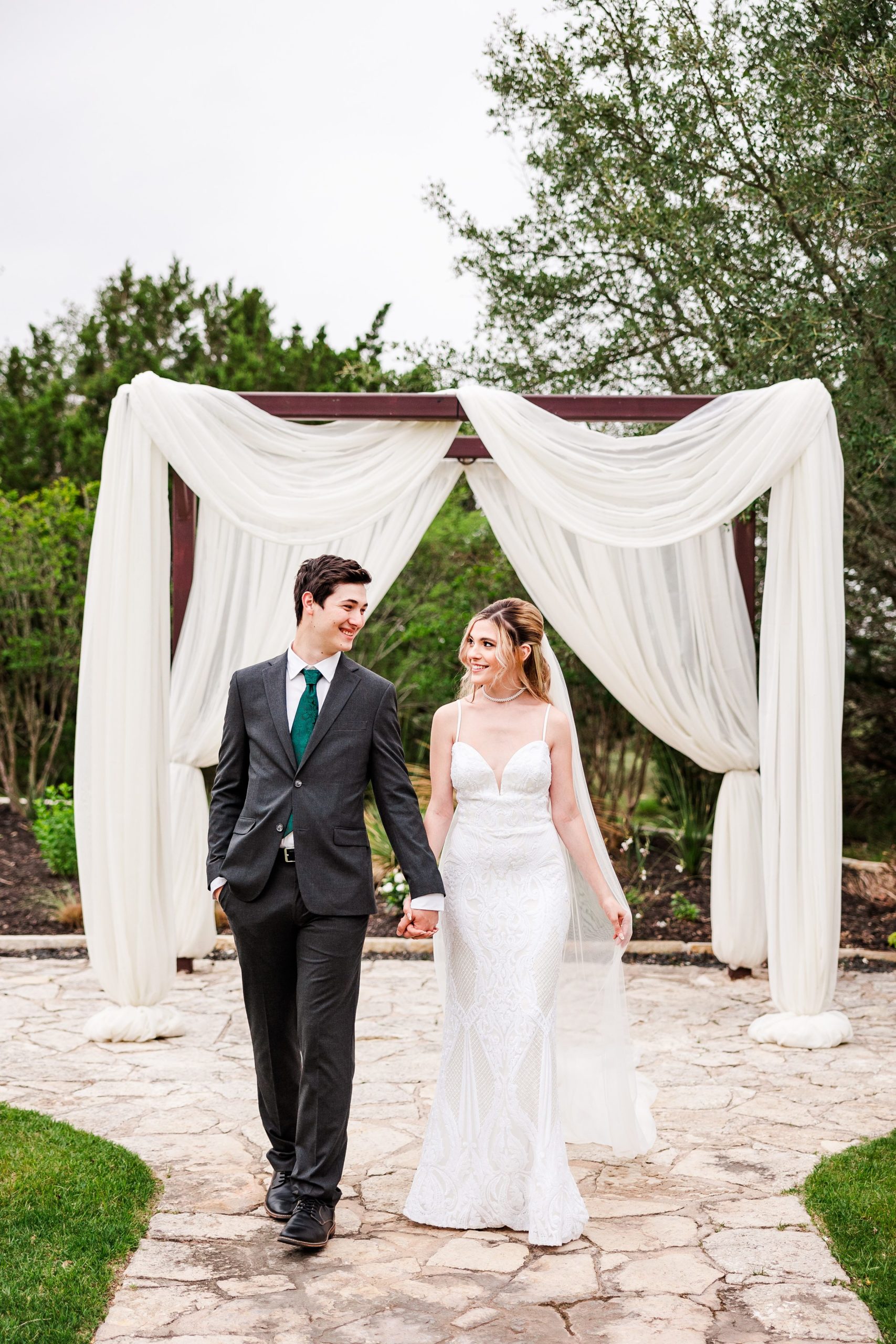 Bride and groom walk during their wedding at the Terrace Club in Dripping Springs, Texas.