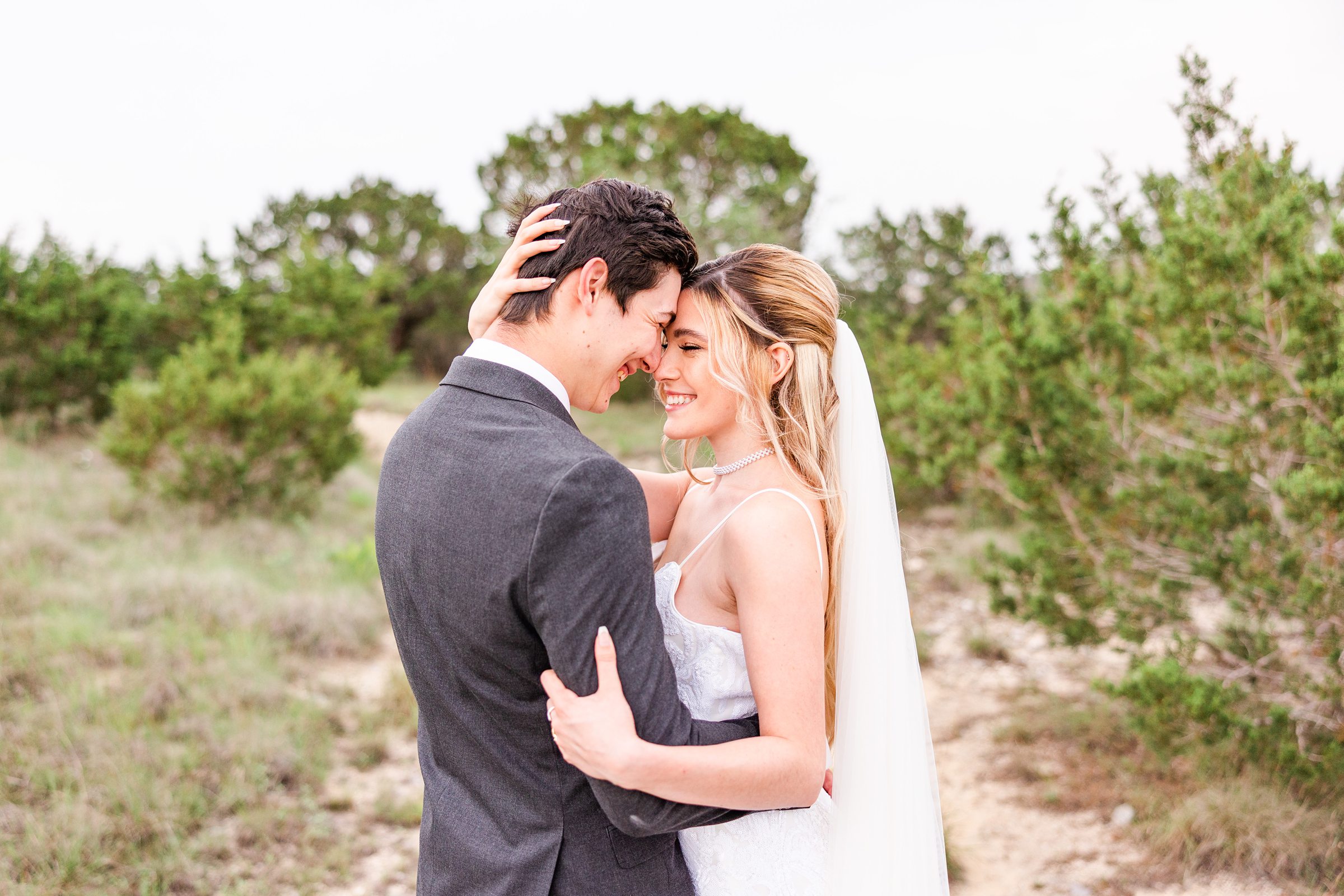 Bride and groom embrace during their wedding at the Terrace Club in Dripping Springs, Texas.