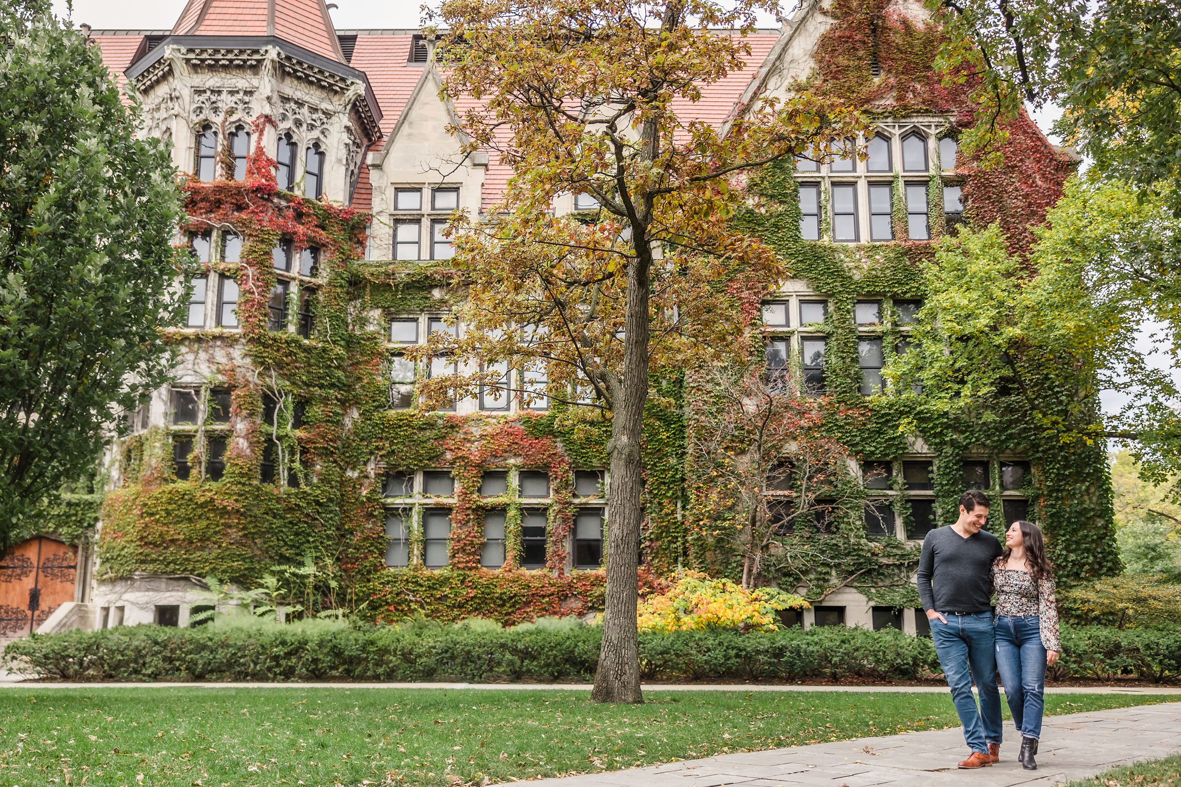 Couple walk together during their engagement session at the University of Chicago in Chicago, Illinois.