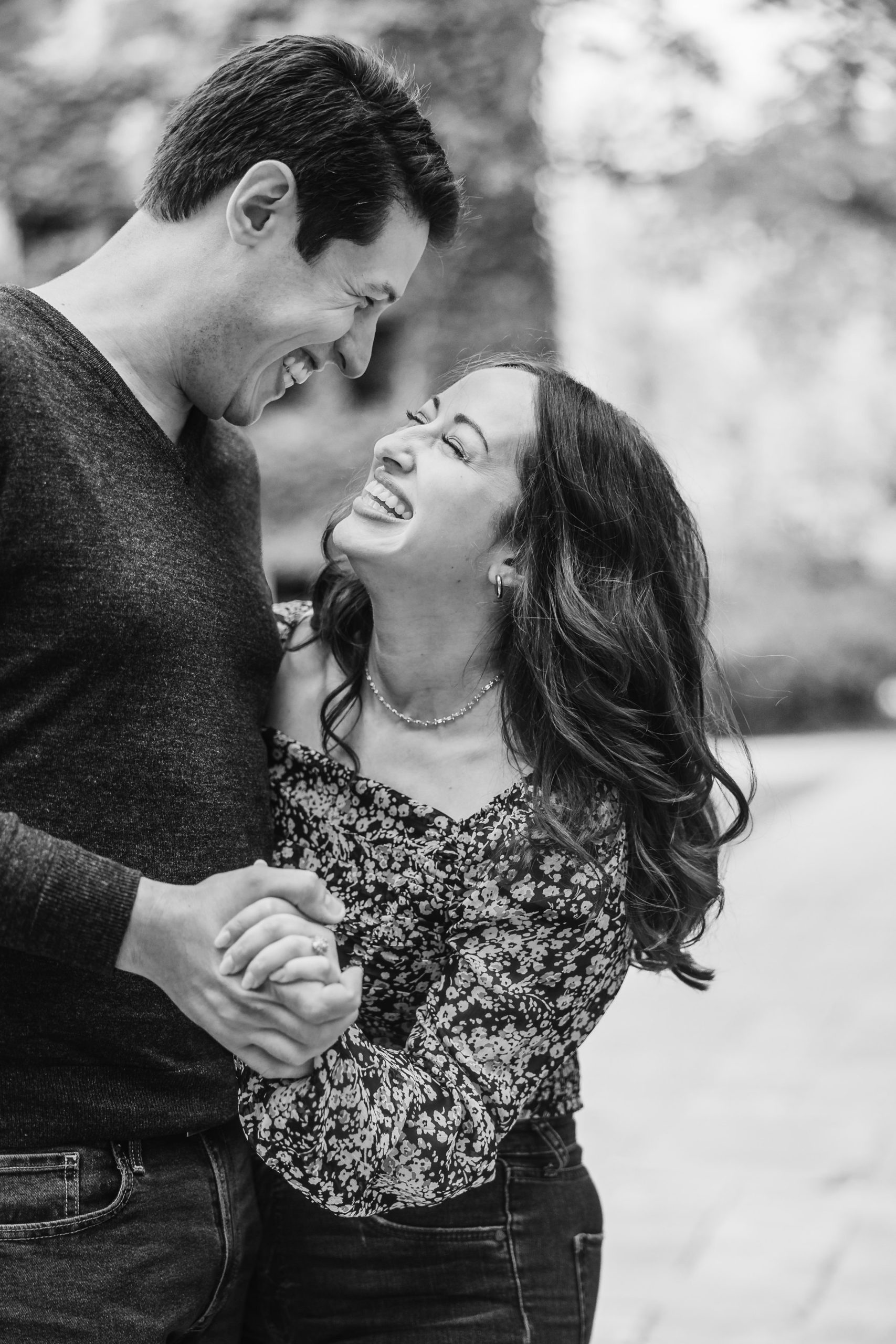 Couple laugh together during their engagement session at the University of Chicago in Chicago, Illinois.