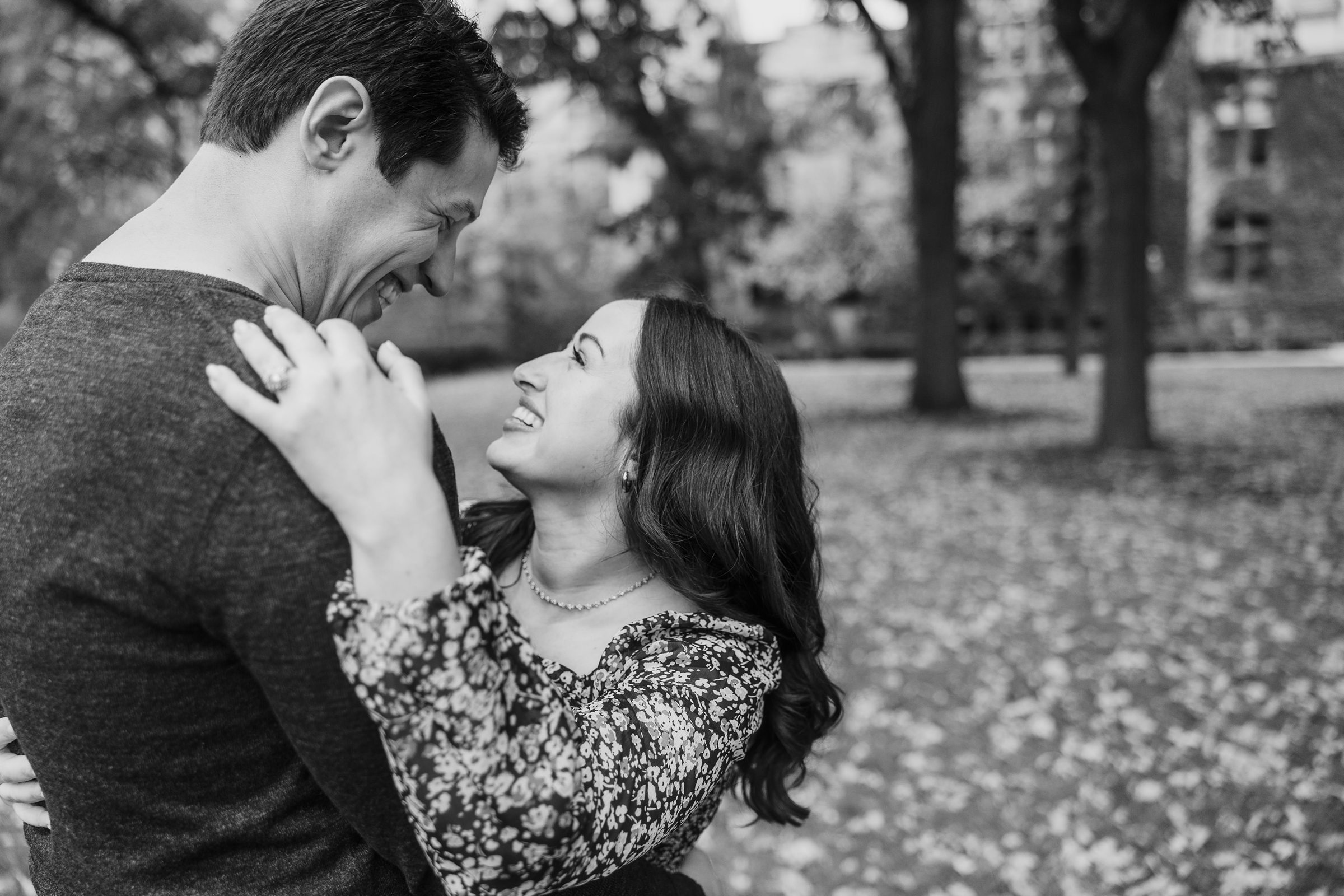 Couple laugh together during their engagement session at the University of Chicago in Chicago, Illinois.