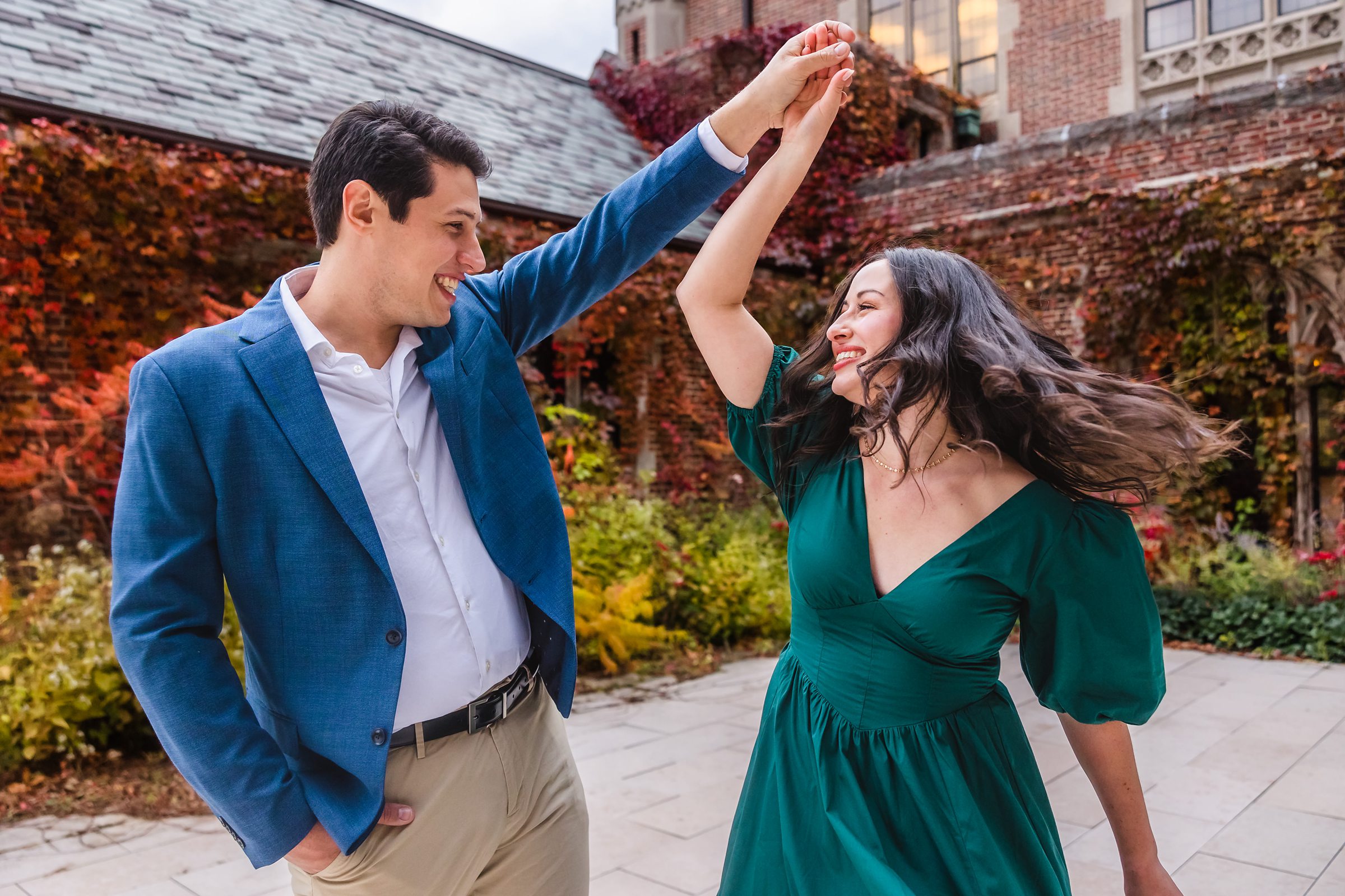Couple twirl during their engagement session at the University of Chicago in Chicago, Illinois.