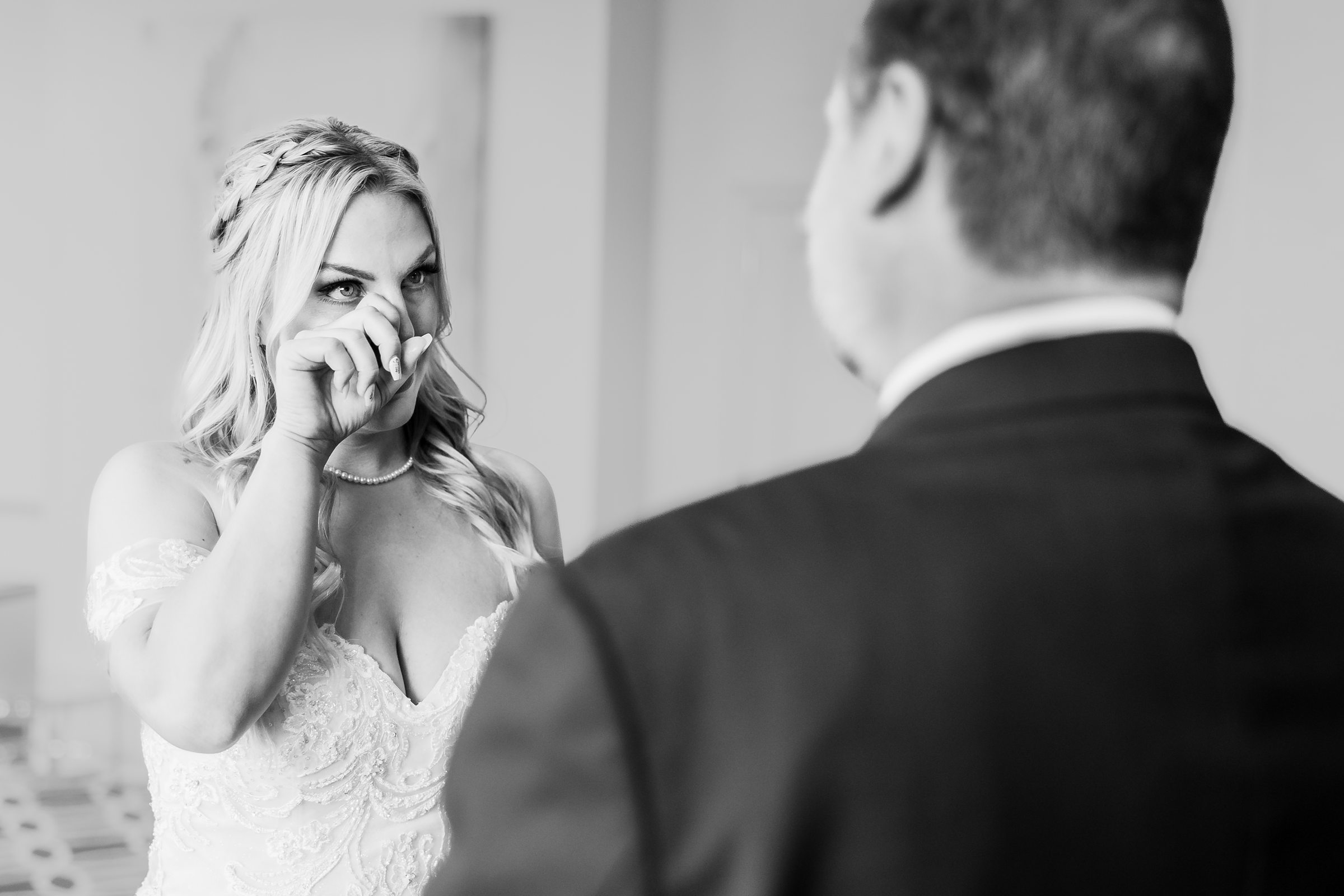 Bride wipes away a tear when she sees her father before her wedding at at the Warehouse on State in Peoria, Illinois