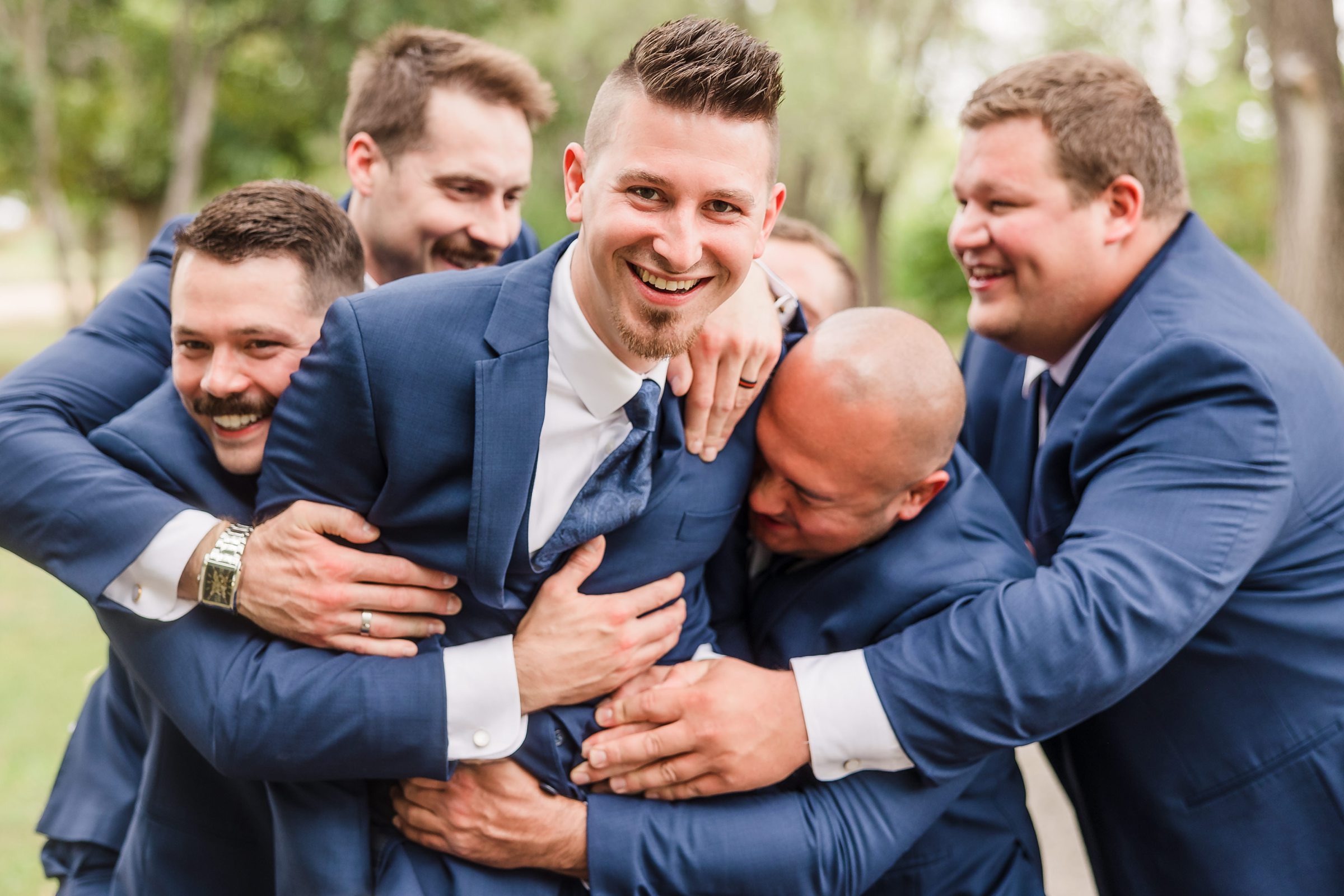 Groomsmen surprise the groom at the Peoria Riverfront in Peoria, Illinois