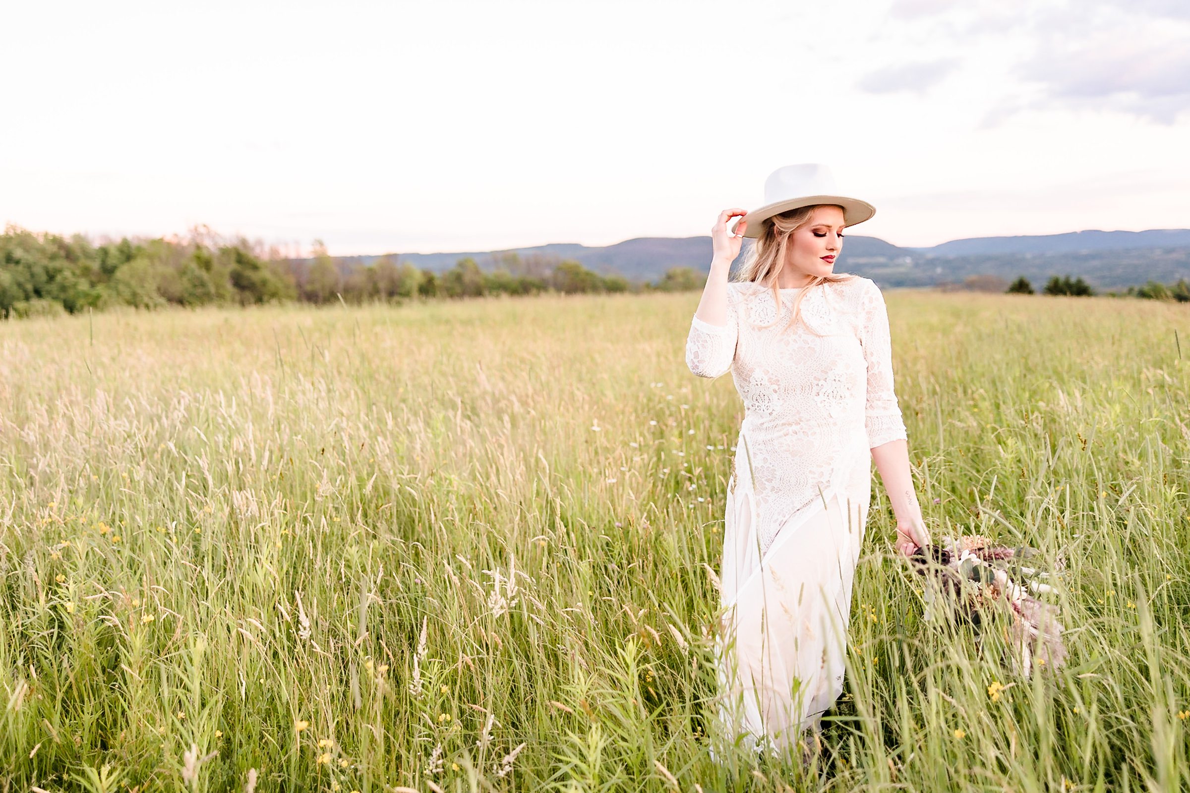 Bride walks around the fields at the Wren's Roost Barn Venue in Naples, New York.