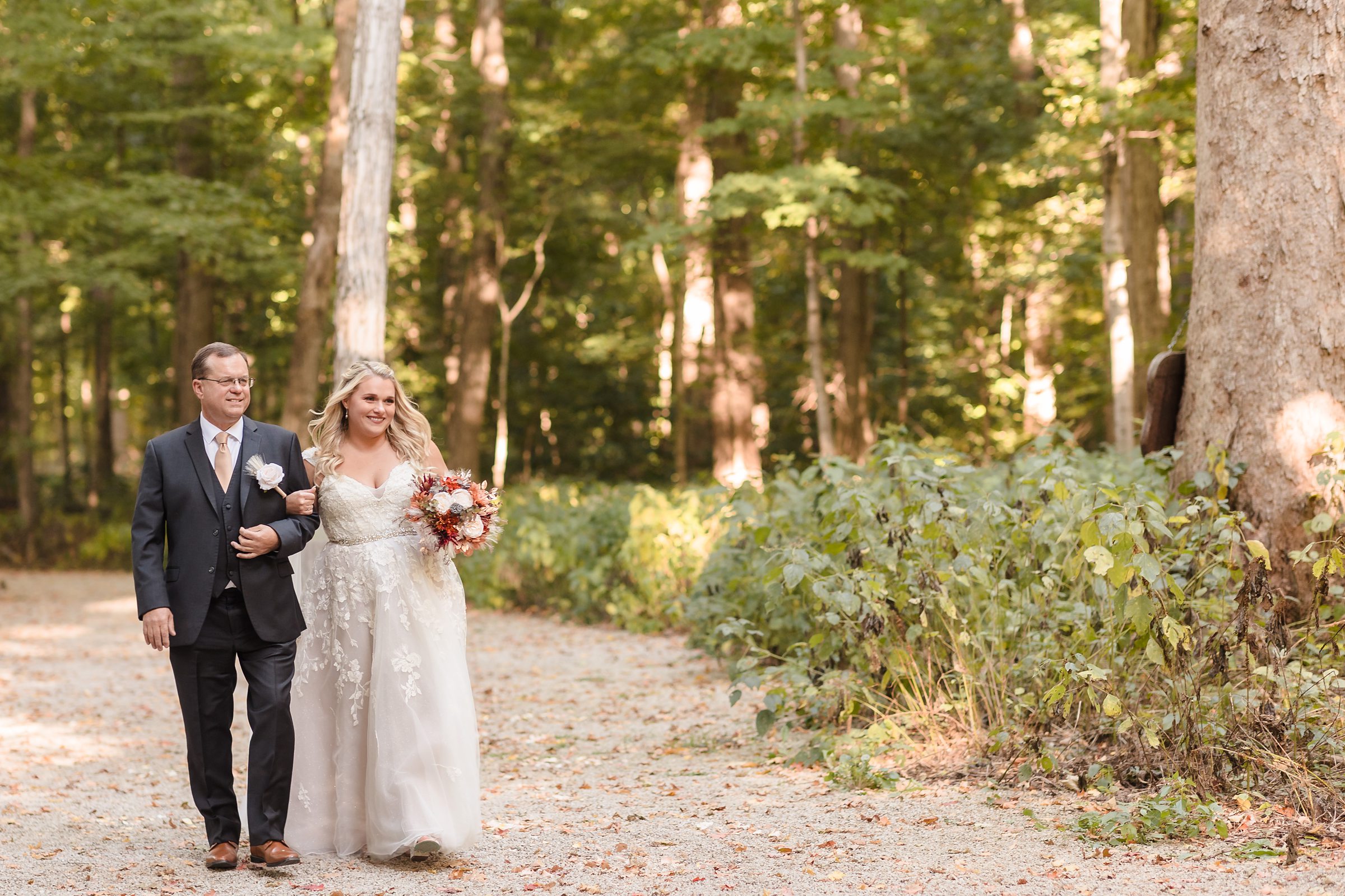Bride and dad walk down the aisle during a wedding ceremony at Funks Grove in Mclean, Illinois.