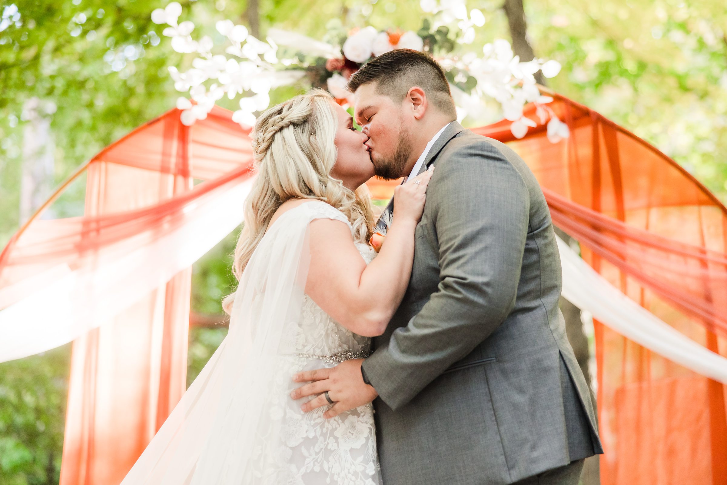 Bride and Groom share their first kiss during a wedding ceremony at Funks Grove in Mclean, Illinois.