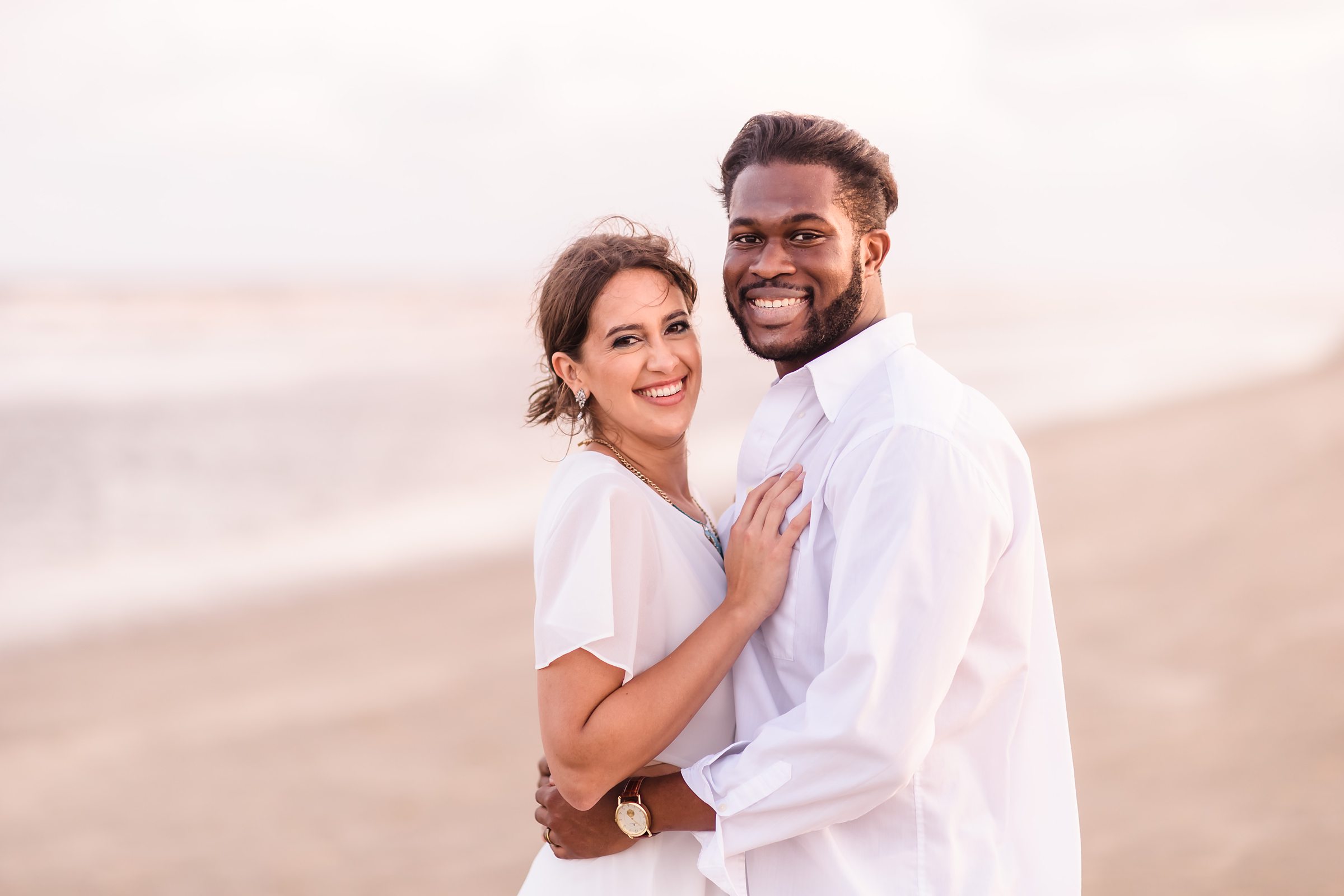 Couple embrace during their session at Galveston Beach in Texas.