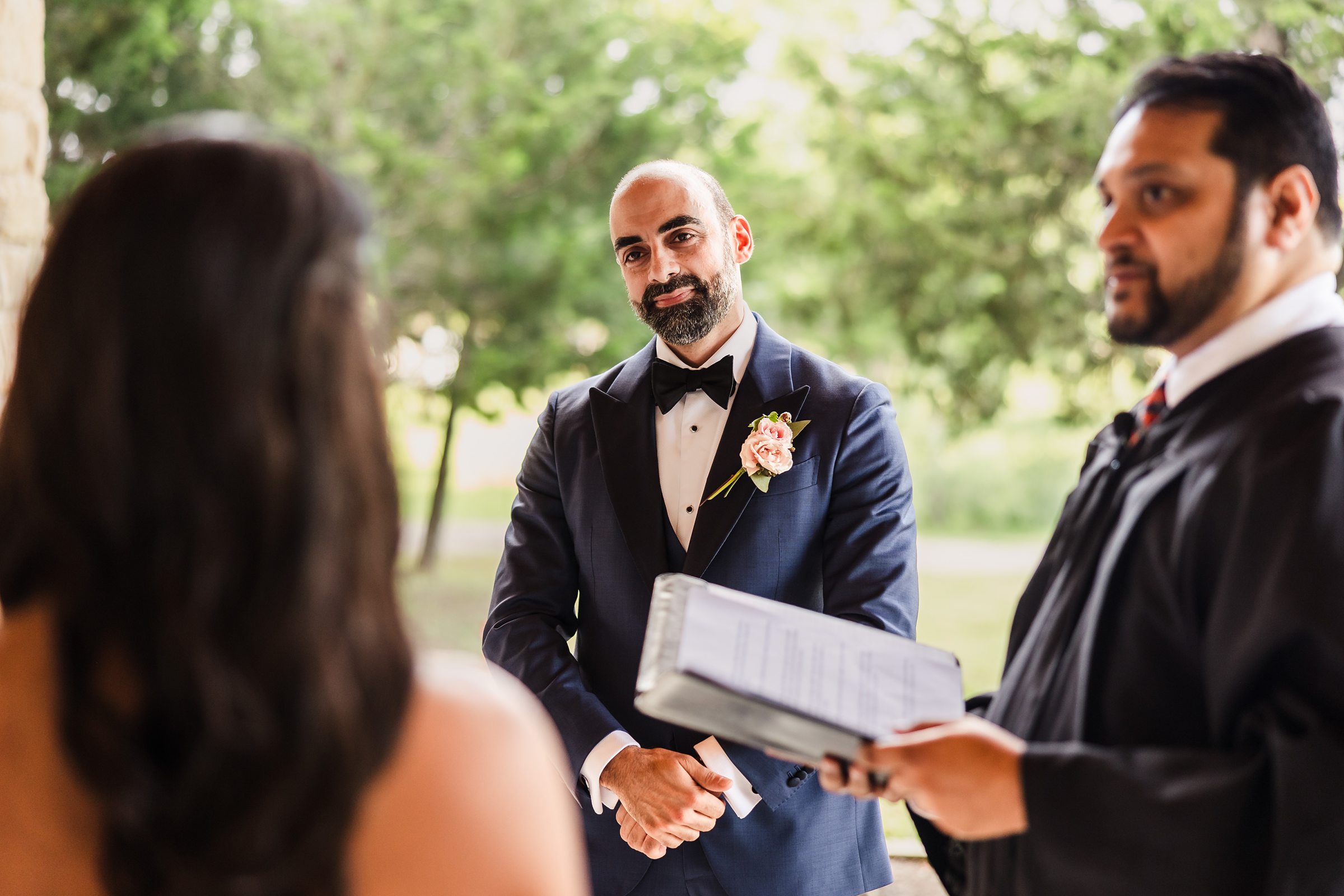 Groom looks at bride during a wedding at Shiraz Garden in Bastrop, Texas.